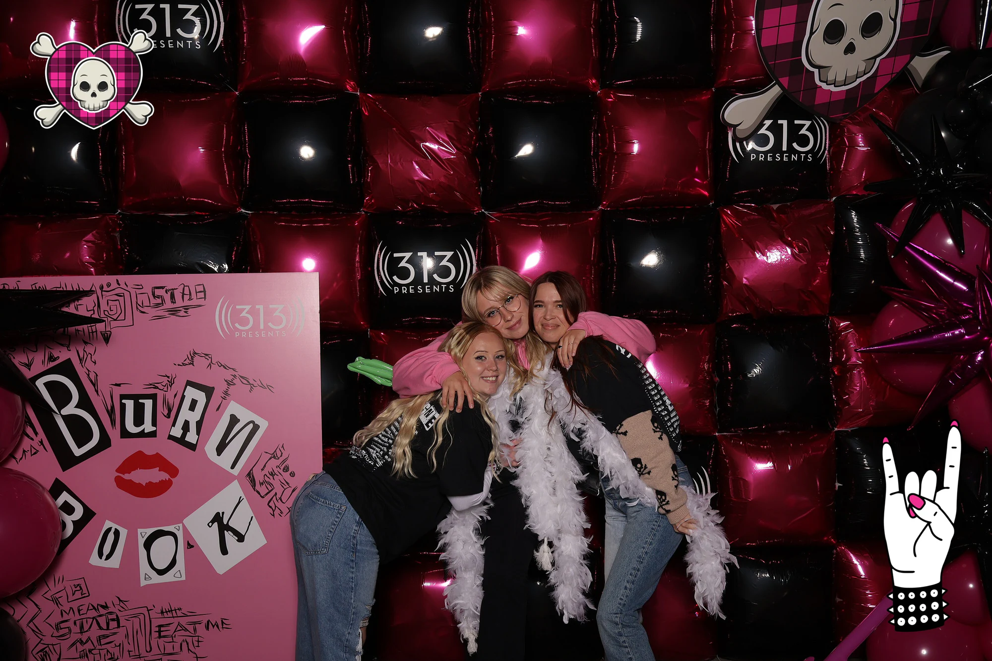 Three friends in feather boas leaning into the balloon wall at Avril Lavigne VIP Party at Pine Knob
