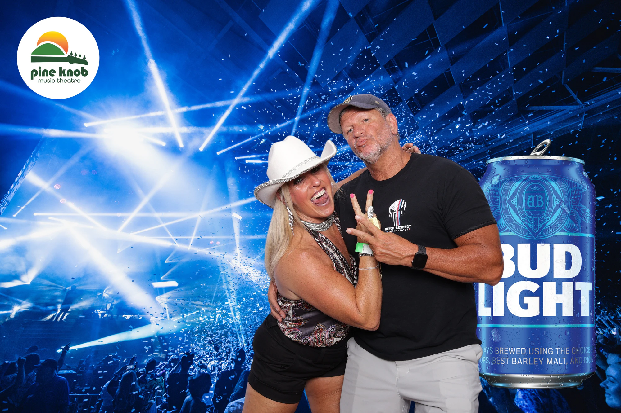 A guest in a white cowboy hat leaning into a friend throwing a peace sign by the giant can at Bud Light Tailgate at Pine Knob, 2024