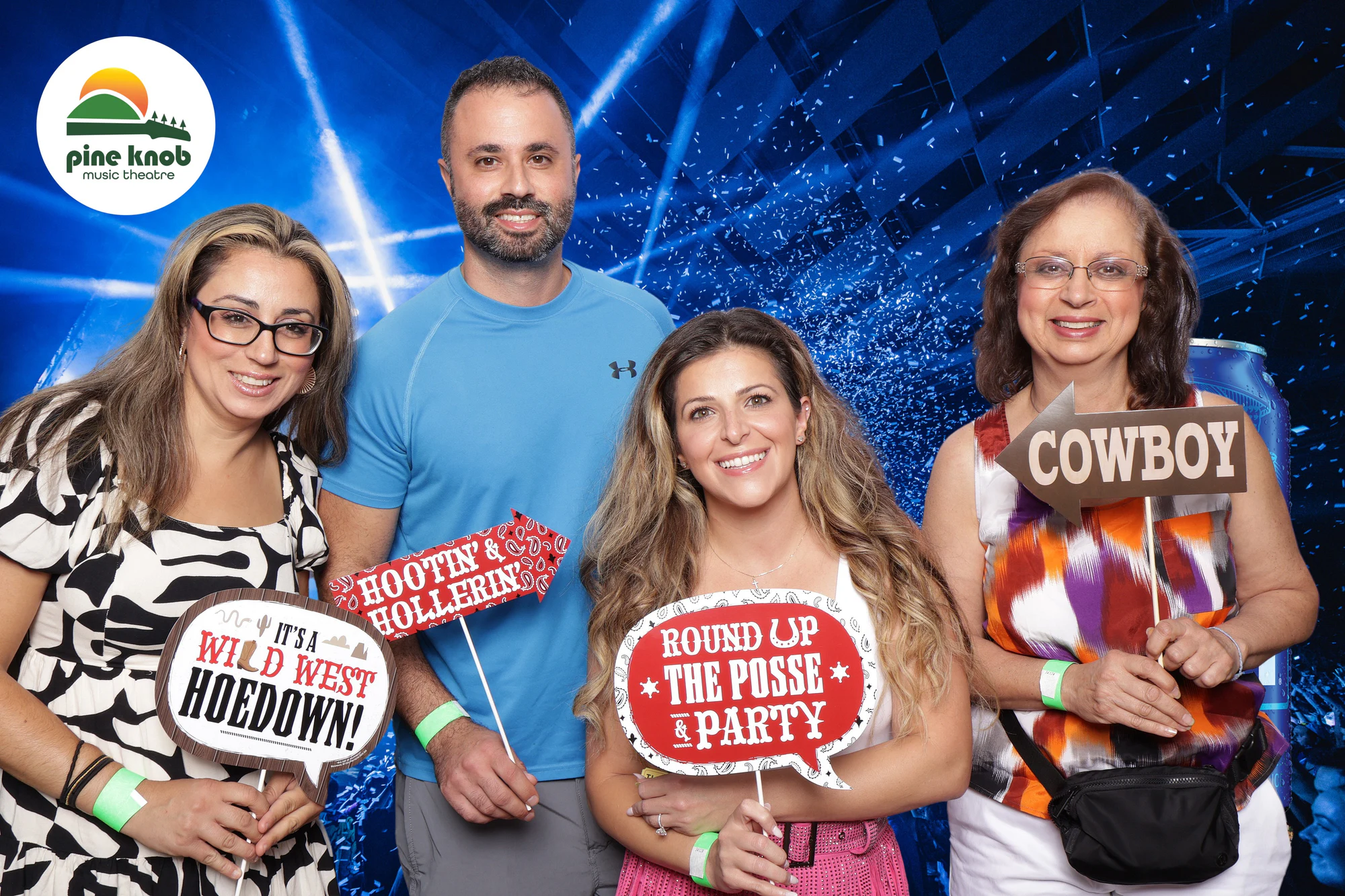 Four guests holding Wild West Hoedown, Round Up the Posse and Cowboy signs at Bud Light Tailgate at Pine Knob, 2024
