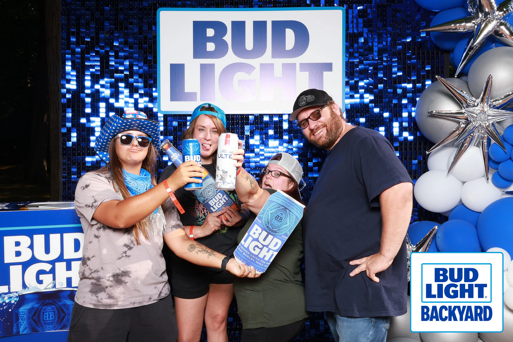 Four guests with their cans up around an oversized Bud Light can at Bud Light Tailgate for Luke Bryan, 2026