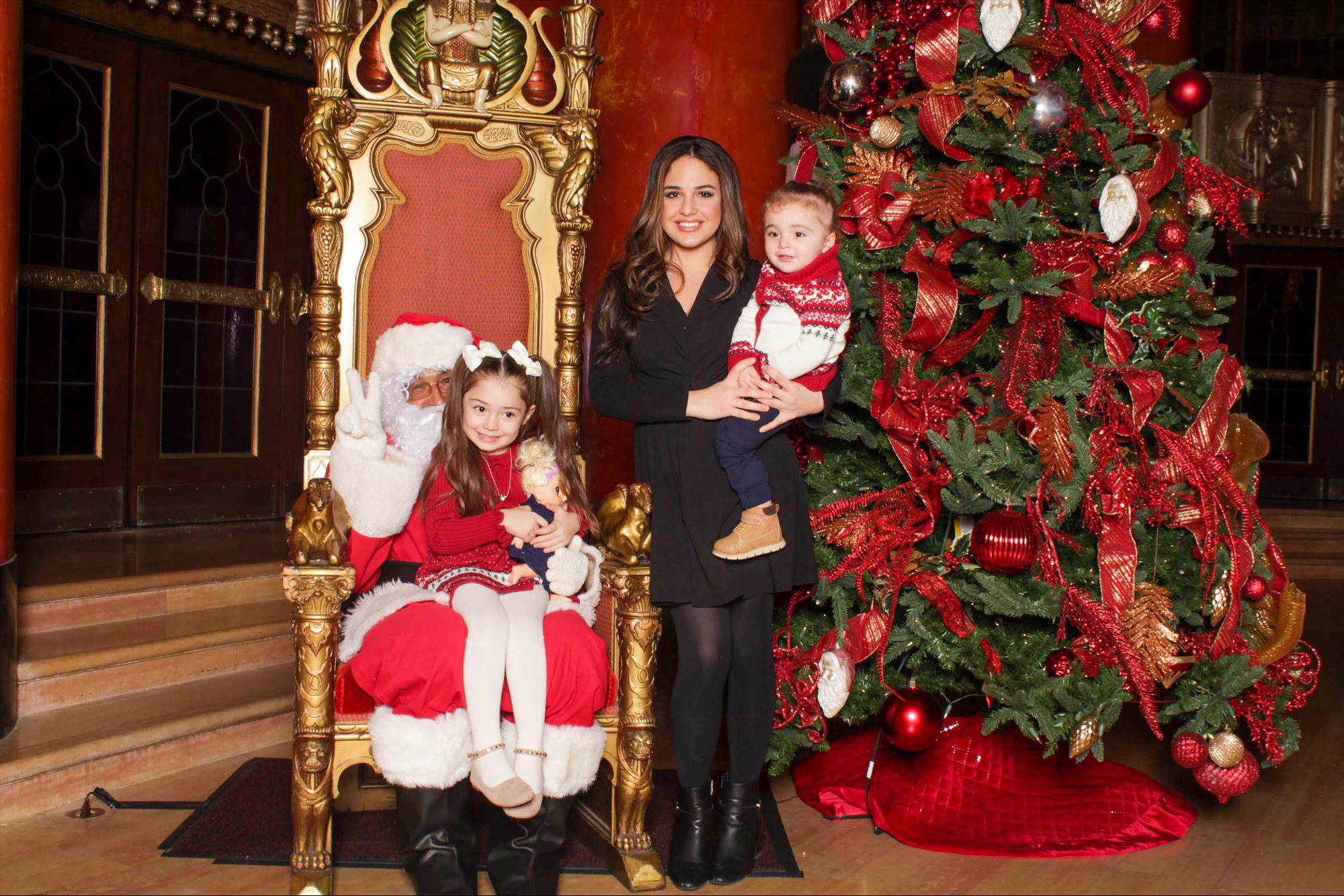 A family with Santa beside the tree at the 313 Presents holiday event at the Fox Theatre