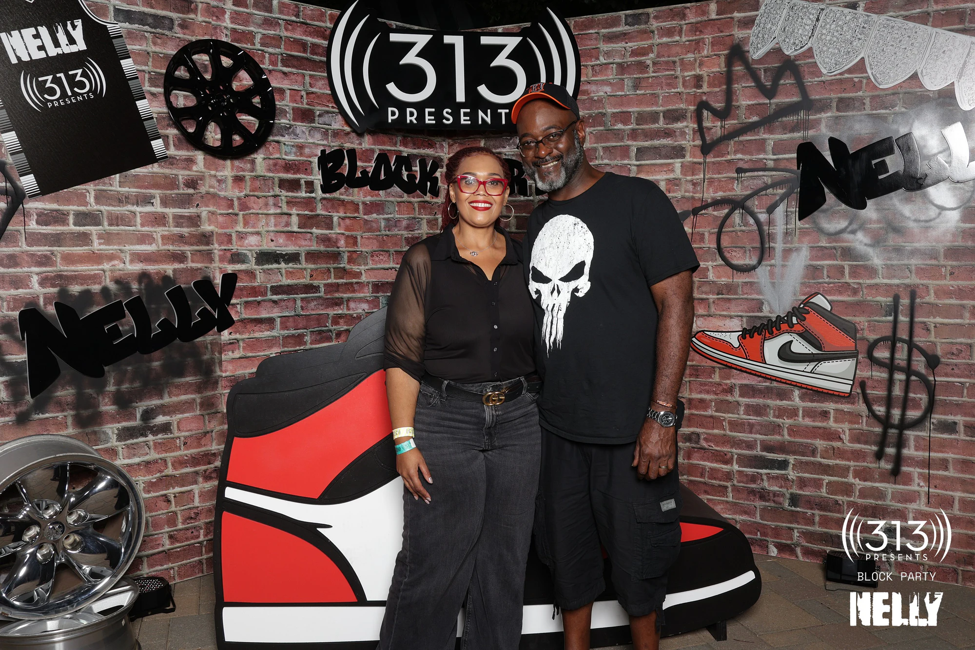 A couple standing in front of the giant sneaker at Nelly Block Party with 313 Presents
