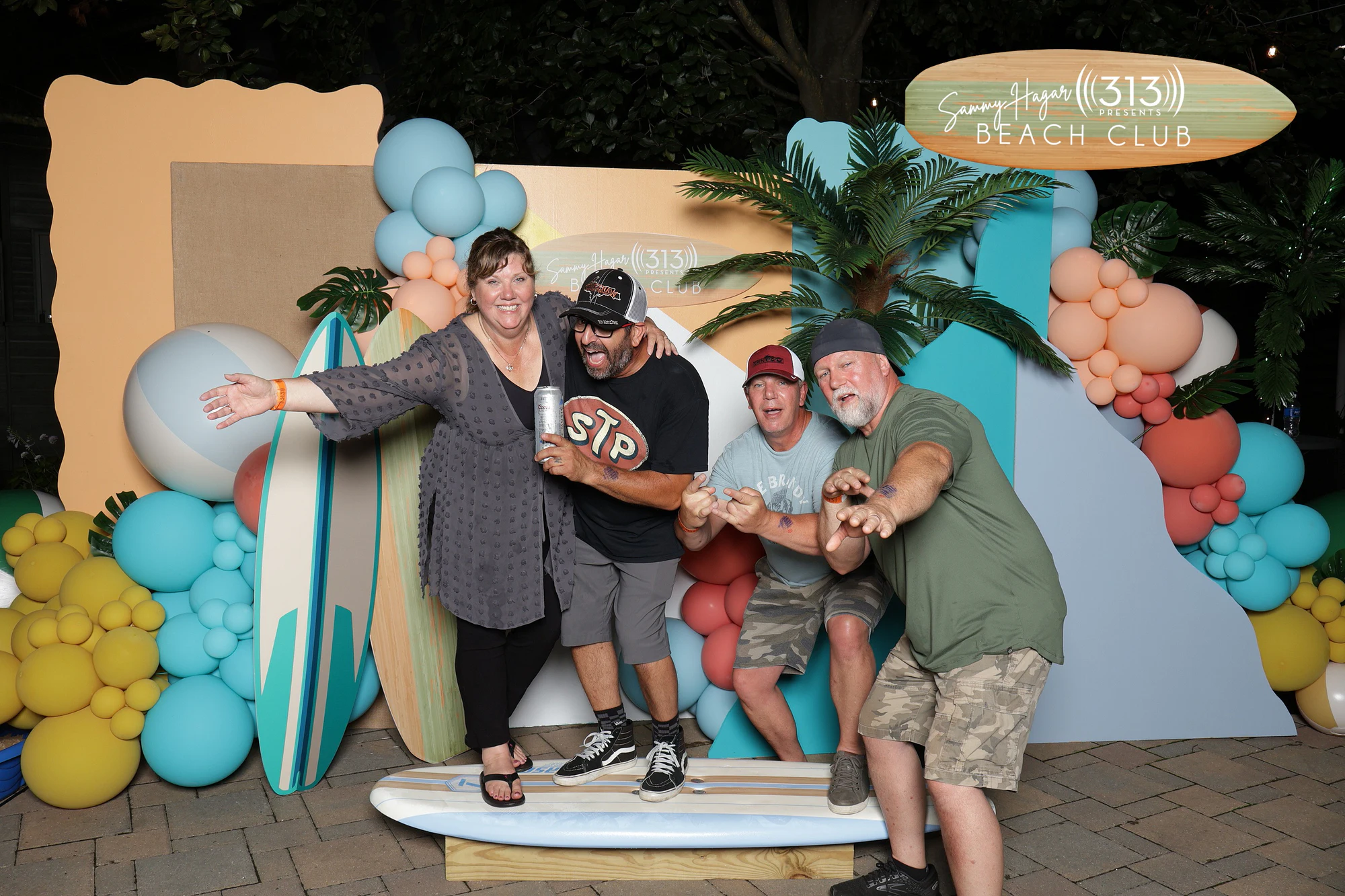 Four guests crowded onto the surfboard, one holding a can at Sammy Hagar at Pine Knob with 313 Presents