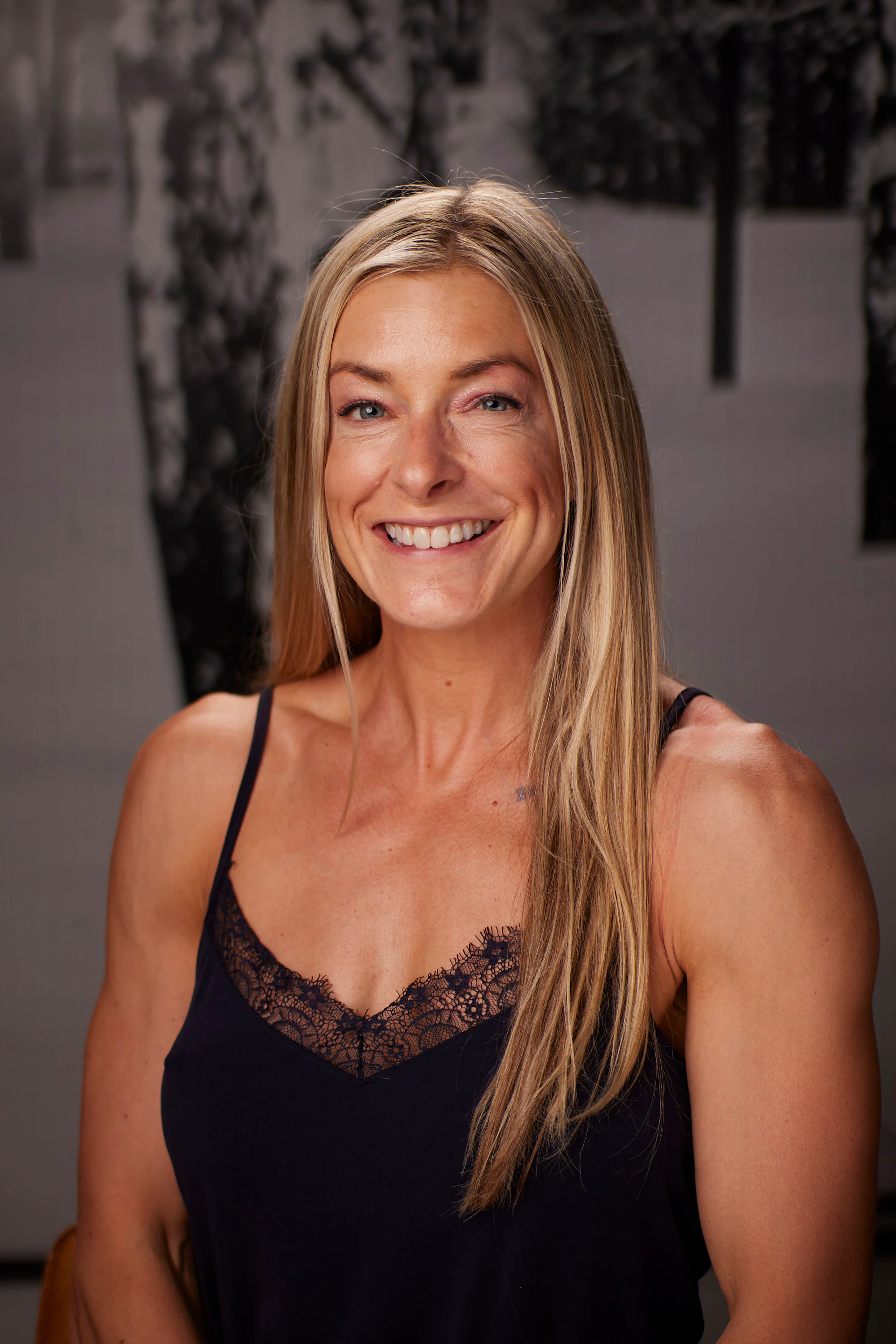 A headshot of a guest with long blonde hair in a black camisole at the AMITY Coworking grand reopening