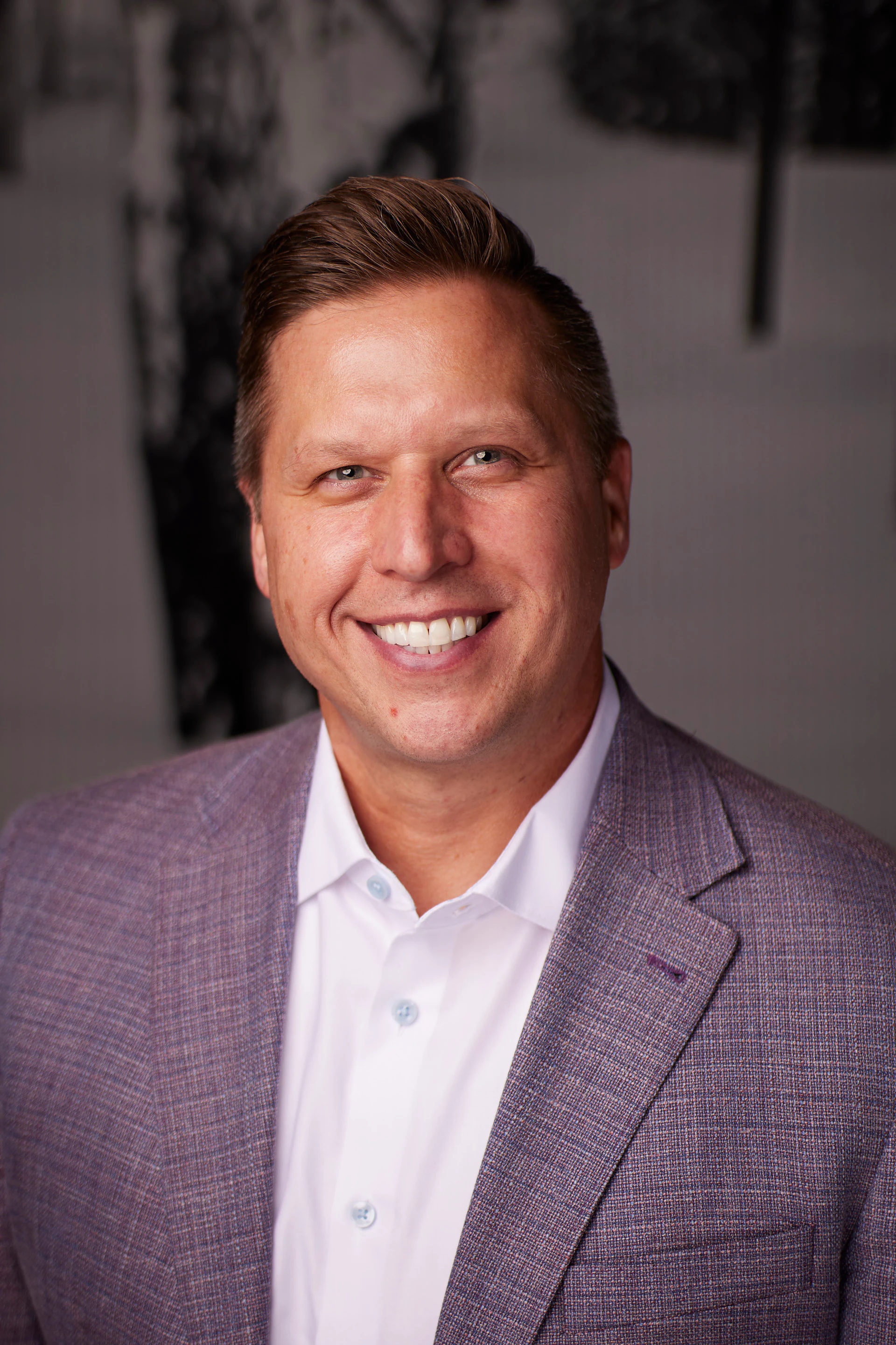 A headshot of a guest in a grey blazer and a white shirt at the AMITY Coworking grand reopening