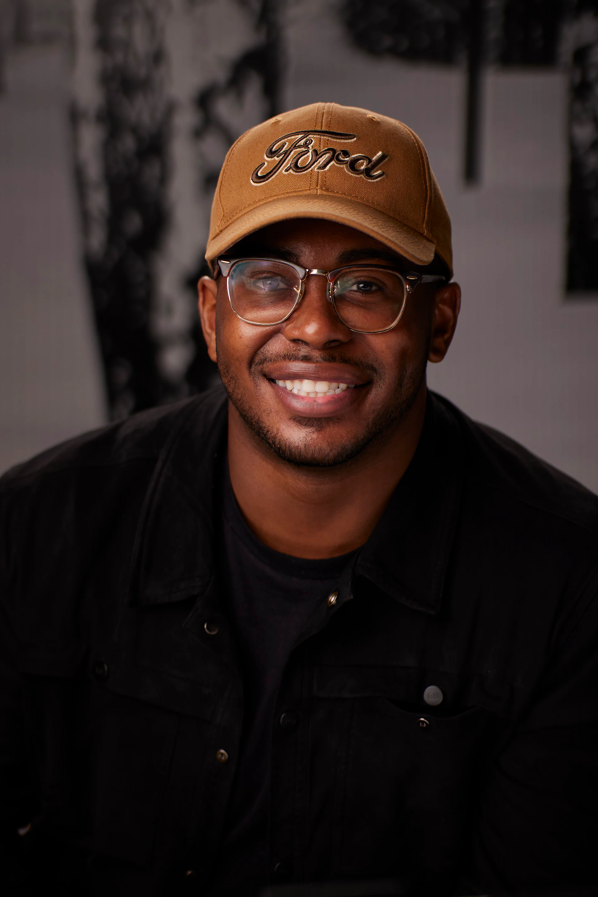 A headshot of a guest in a tan Ford cap, glasses and a black jacket at the AMITY Coworking grand reopening