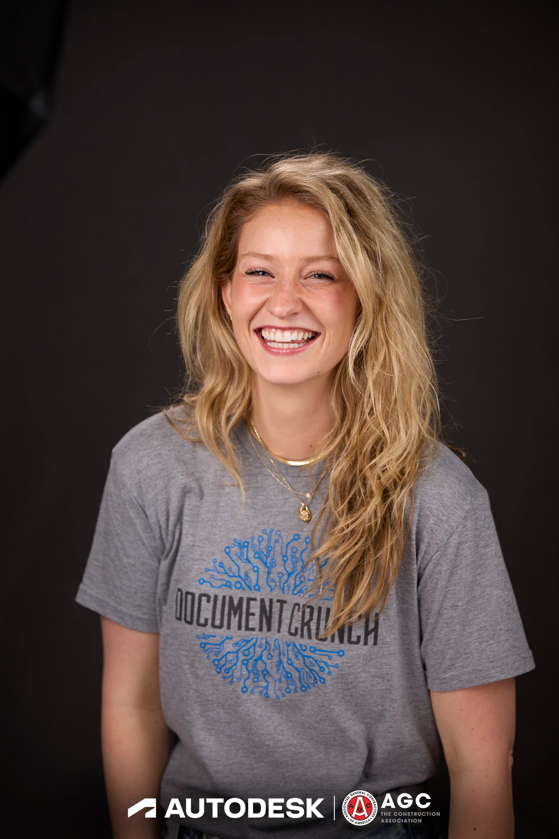 A half-length headshot of a guest in a grey tee, laughing, at Autodesk at the AGC Annual Convention 2025