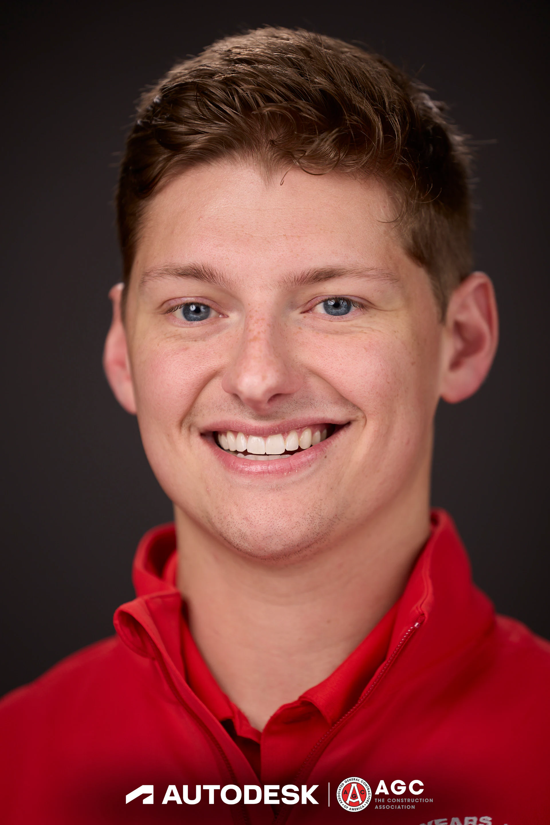 A close headshot of a guest in a red quarter-zip at Autodesk at the AGC Annual Convention 2025