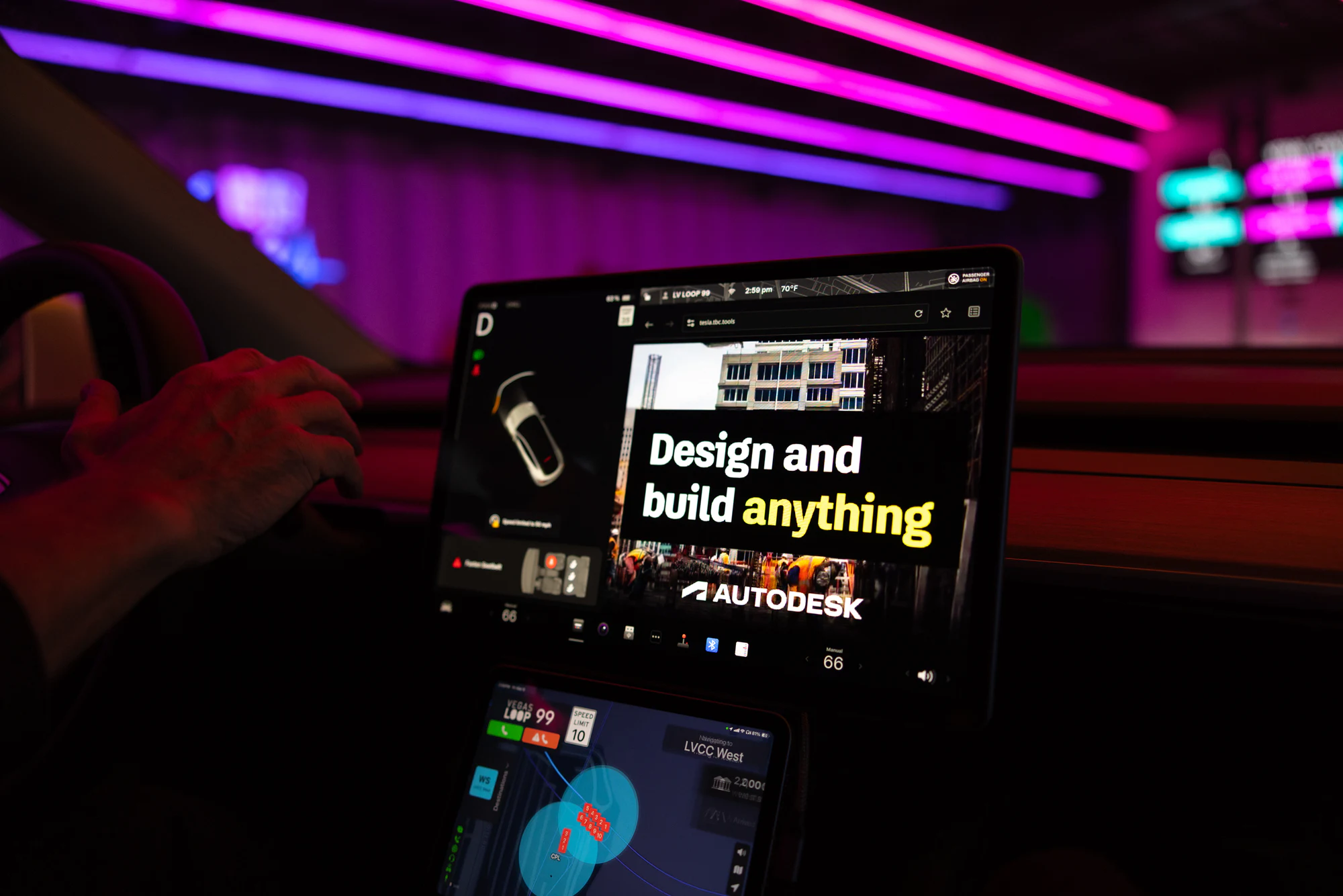 Inside a Tesla in the Loop: Autodesk’s “Design and build anything” ad on the dash screen, pink tunnel lights overhead at Autodesk at CONEXPO-CON/AGG 2026