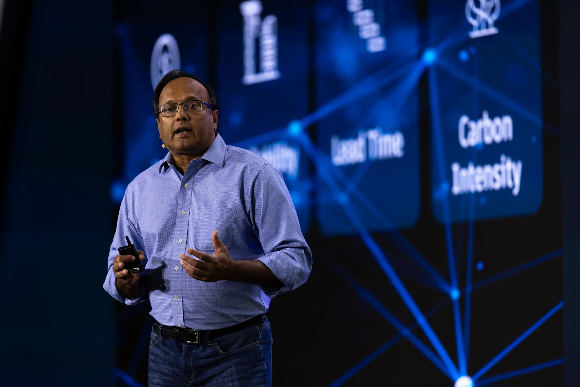 The keynote: a second speaker in a blue shirt in front of a blue network graphic at Autodesk at CONEXPO-CON/AGG 2026