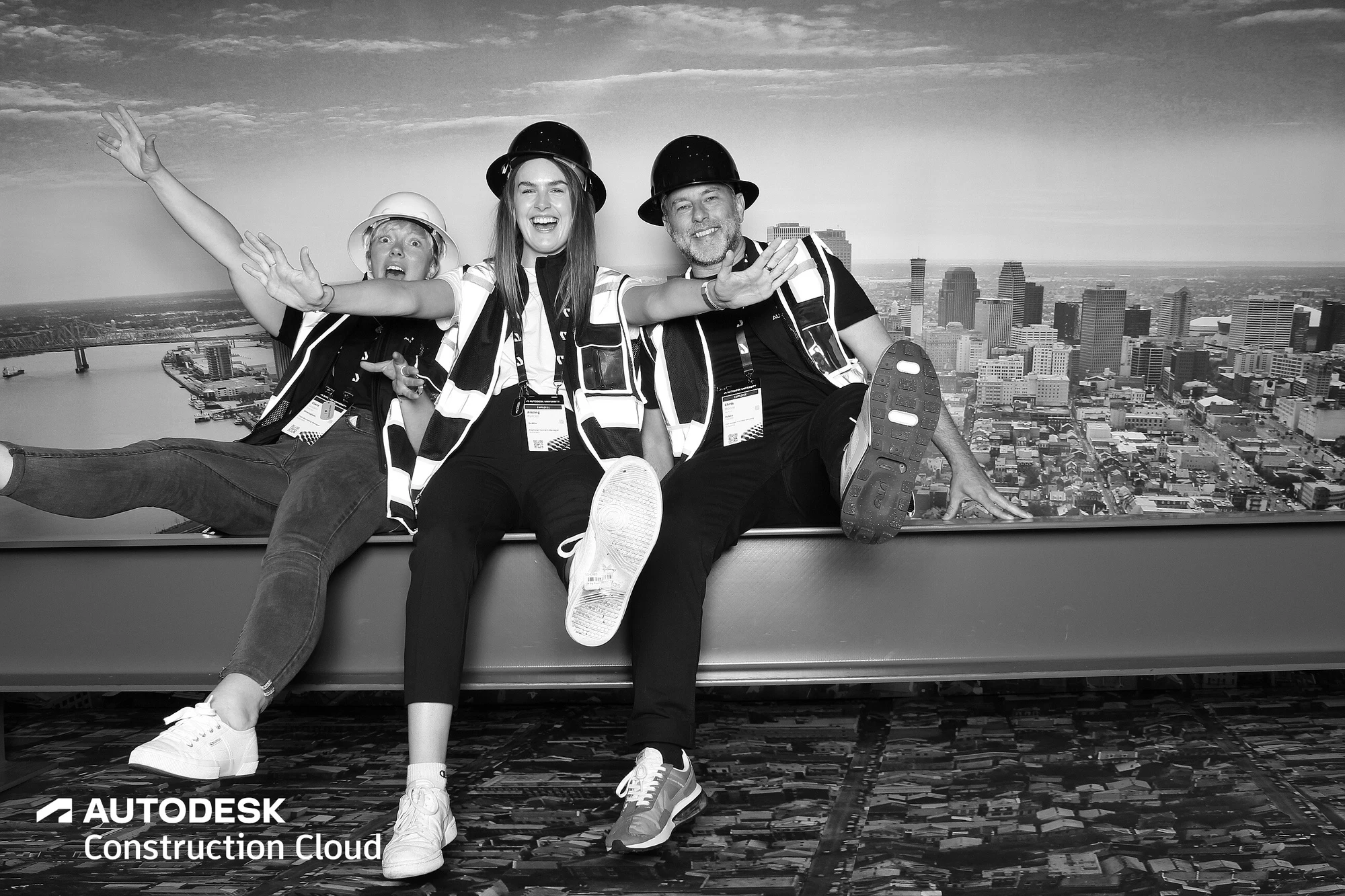 Three with arms up, one waving a hard hat at Autodesk University 2022