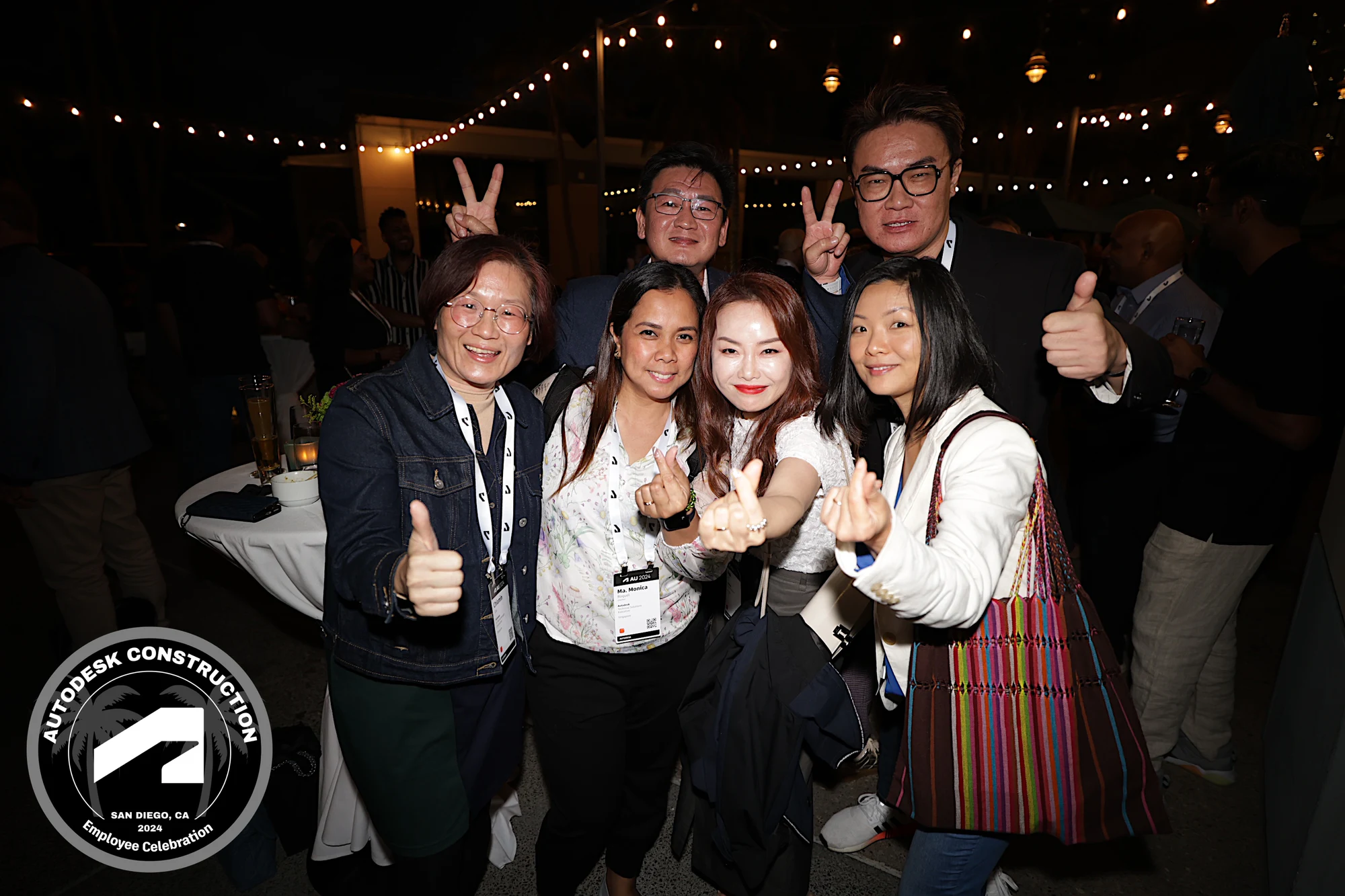 Six with thumbs and peace signs at Autodesk University 2024