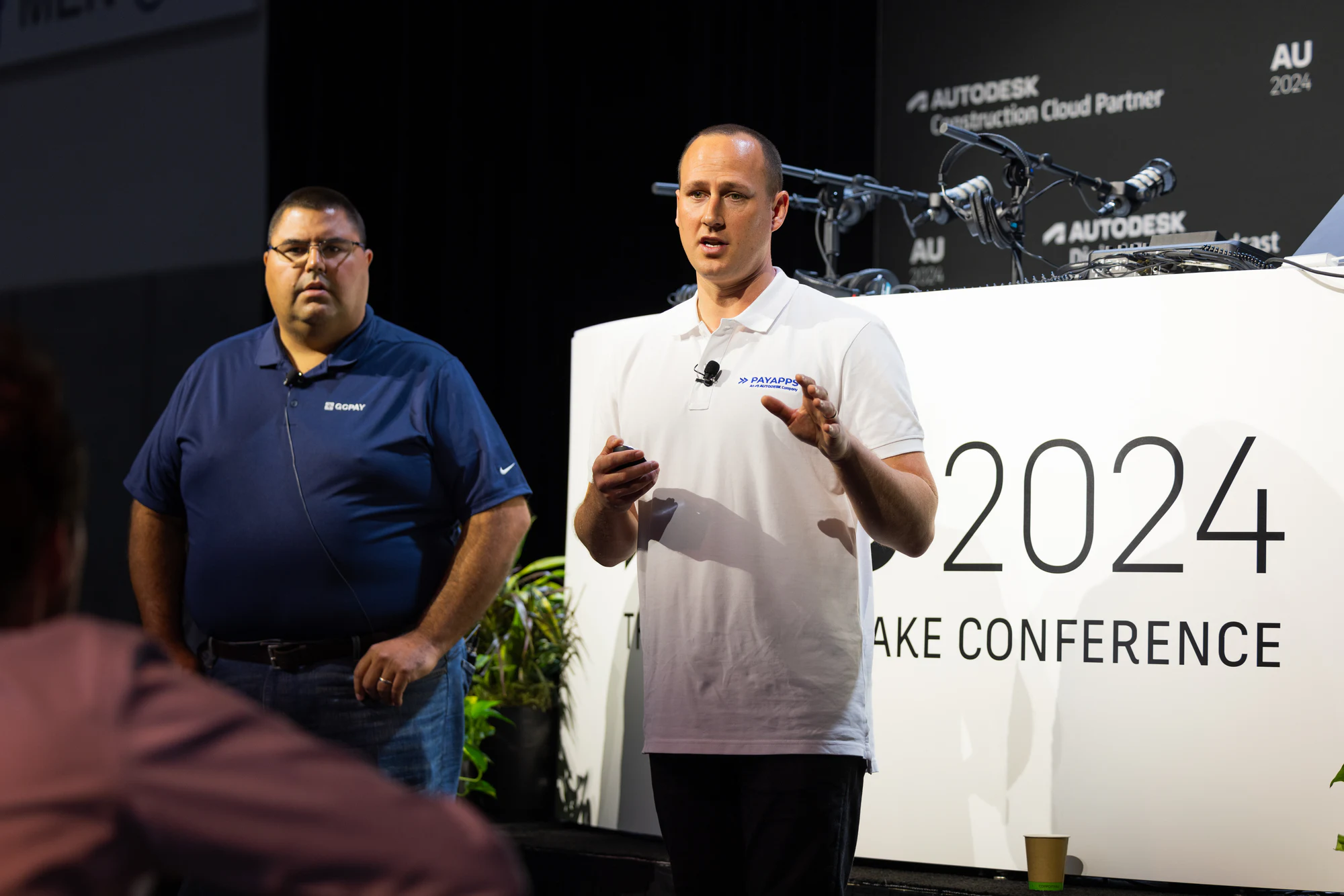 The two presenters mid-talk beside The Design and Make Conference sign at Autodesk University 2024
