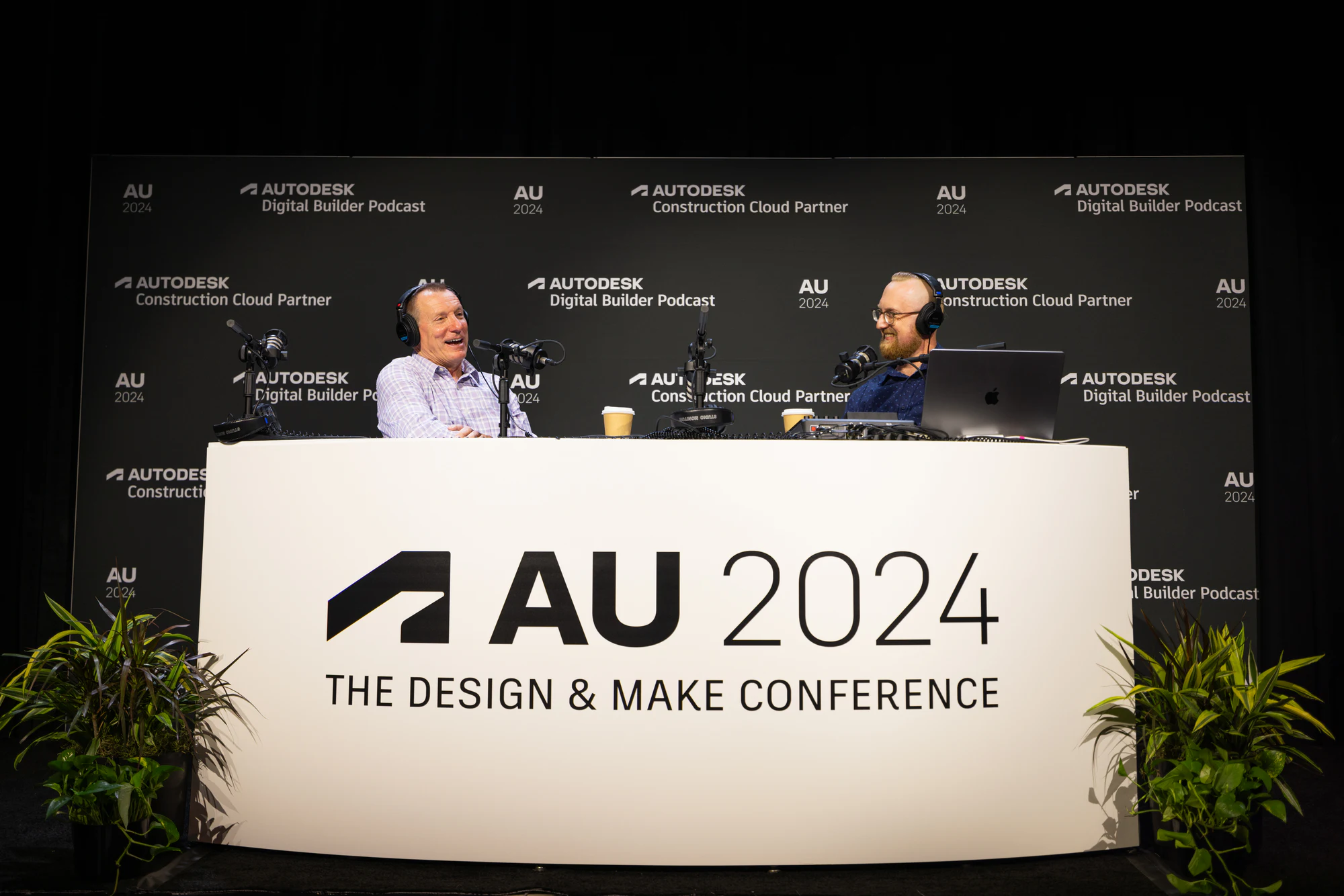 The Digital Builder Podcast set from the front, both hosts behind the AU 2024 desk at Autodesk University 2024