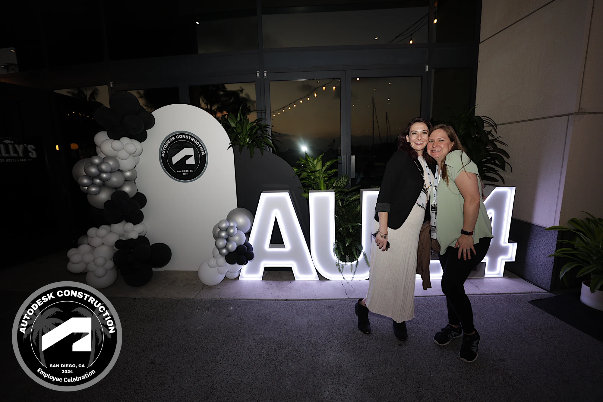 The two coworkers leaning in at the AU24 letters at Autodesk University 2024