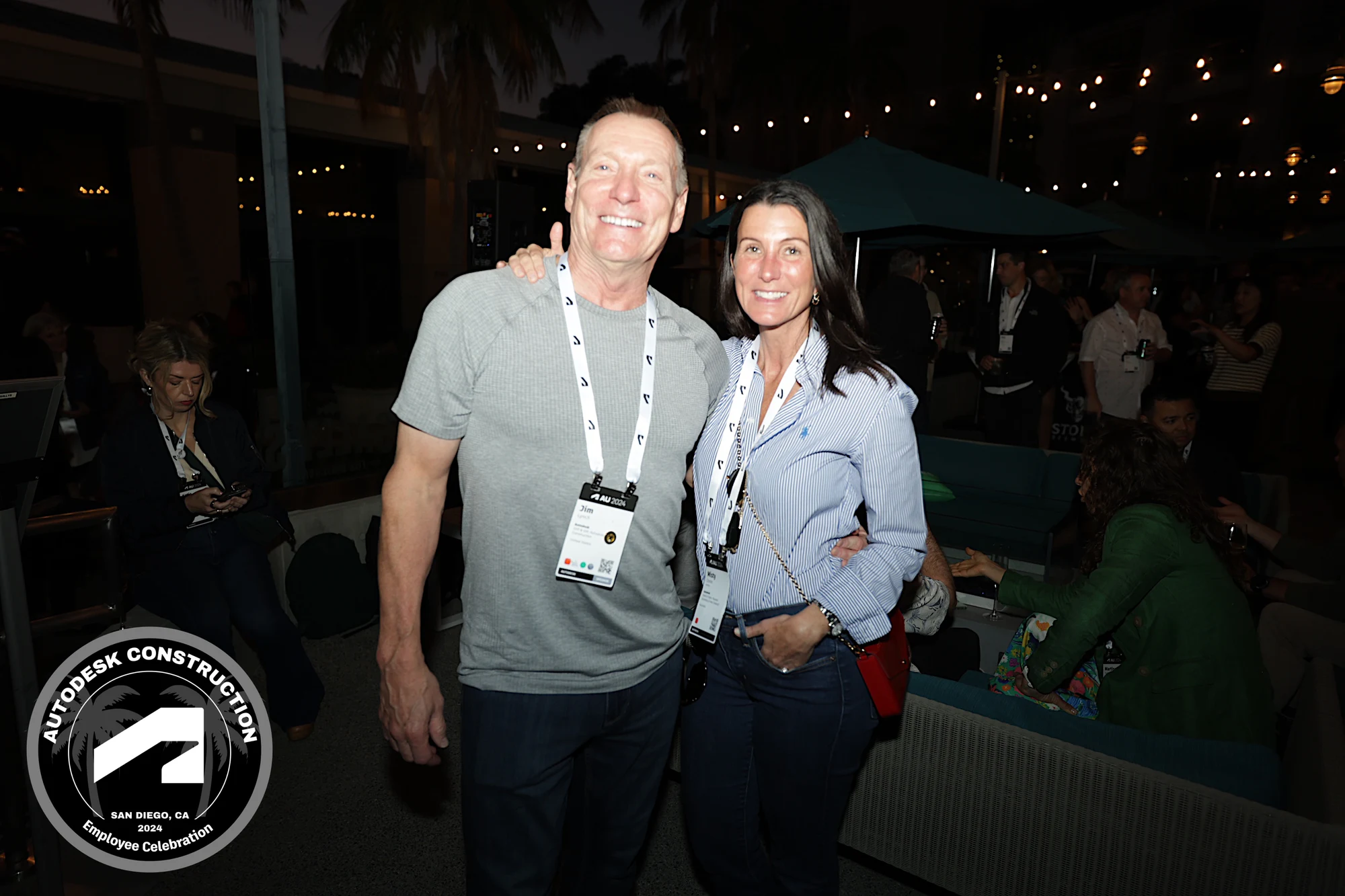 The two coworkers smiling under the string lights at Autodesk University 2024