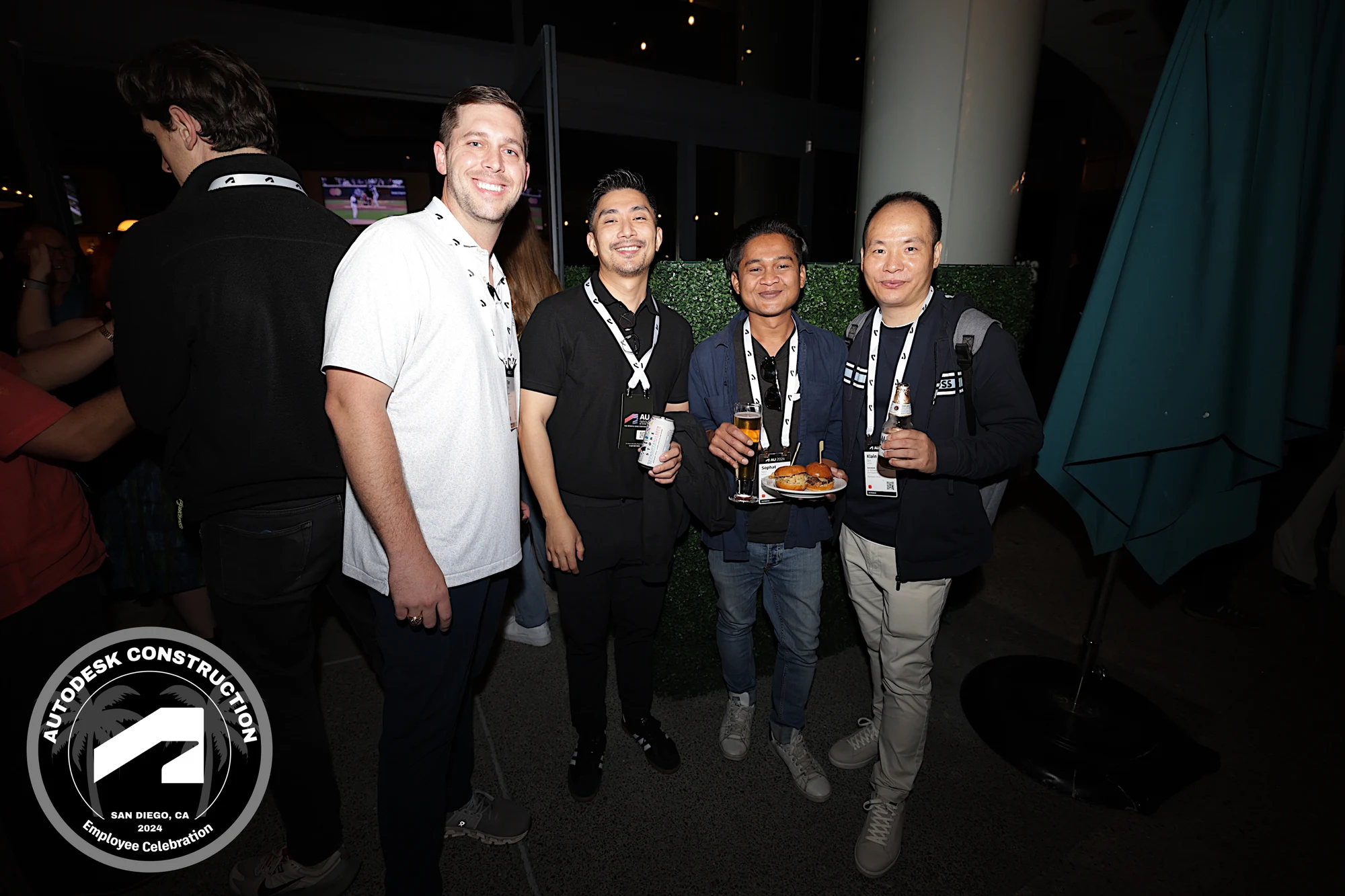 Four coworkers with drinks and sliders on the terrace at Autodesk University 2024