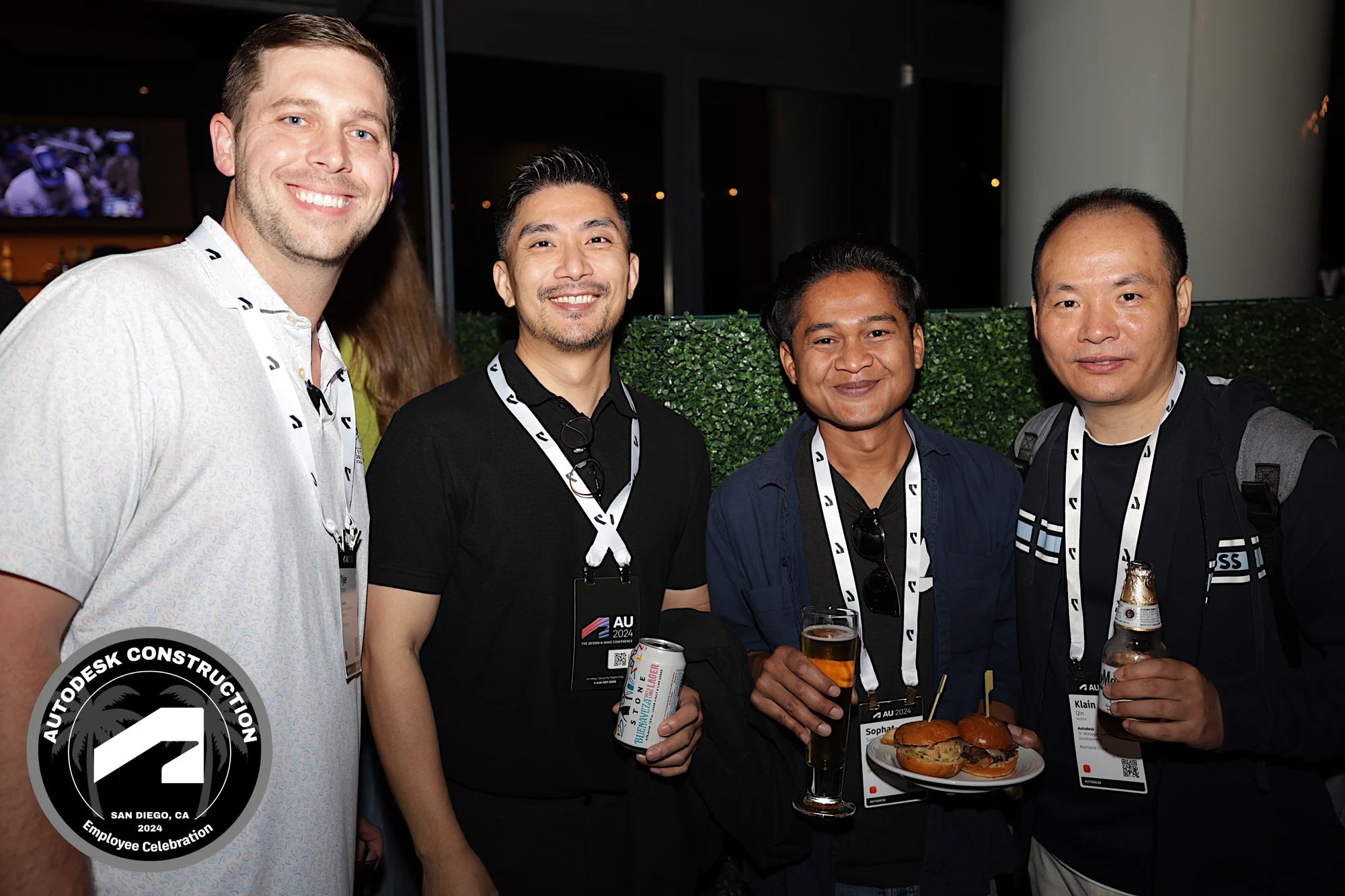 The four coworkers laughing together, drinks in hand at Autodesk University 2024