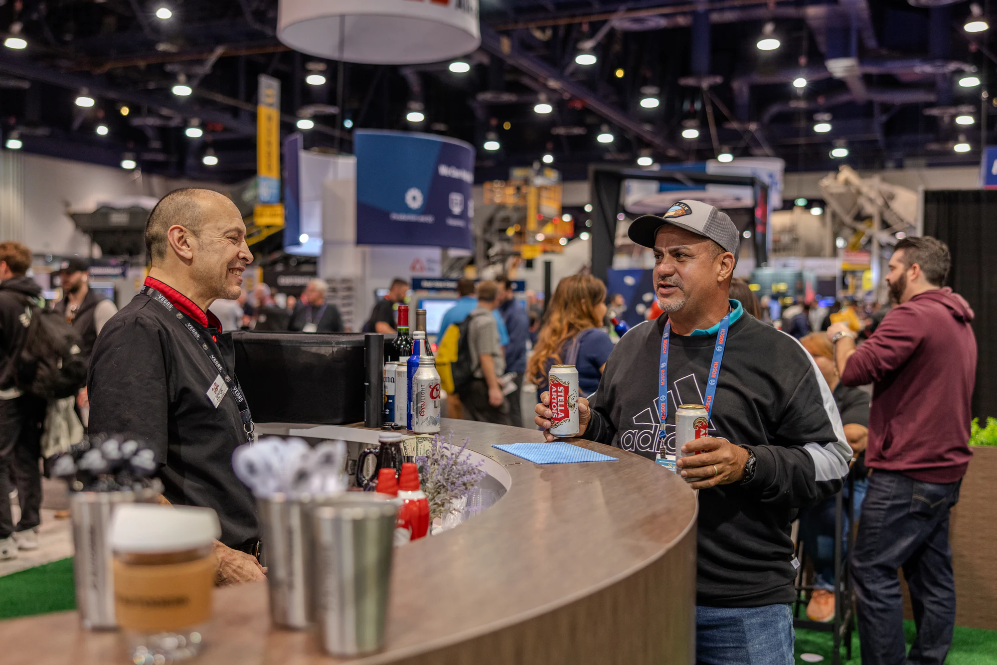 The two at the bar counter with the show floor behind them at Autodesk at World of Concrete 2024