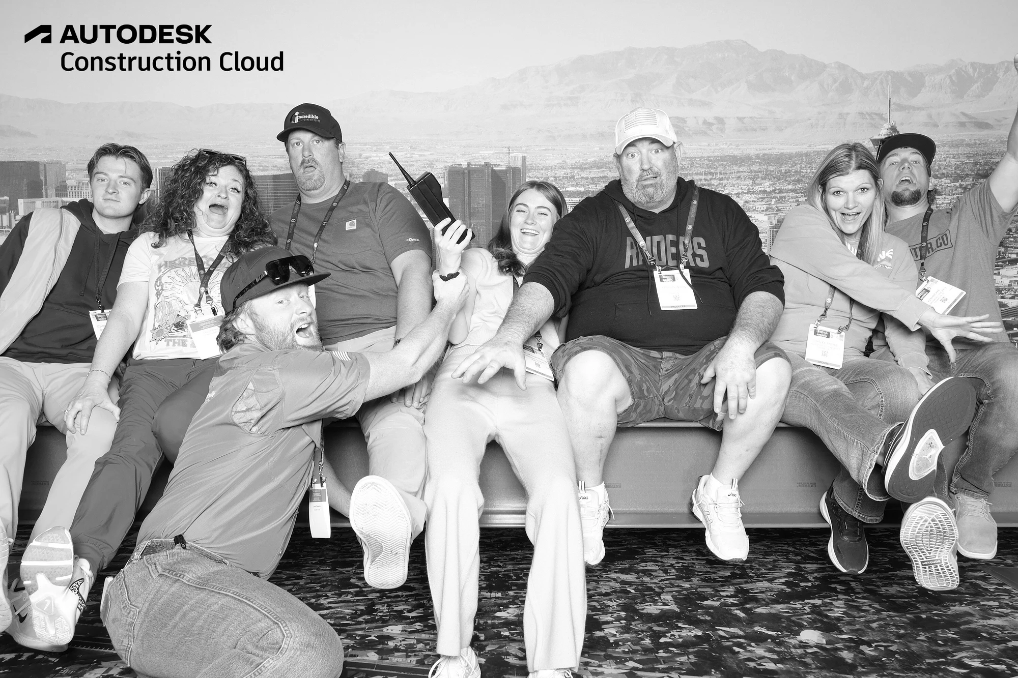 The kneeling guest lunging sideways as the group laughs at Autodesk at World of Concrete 2025