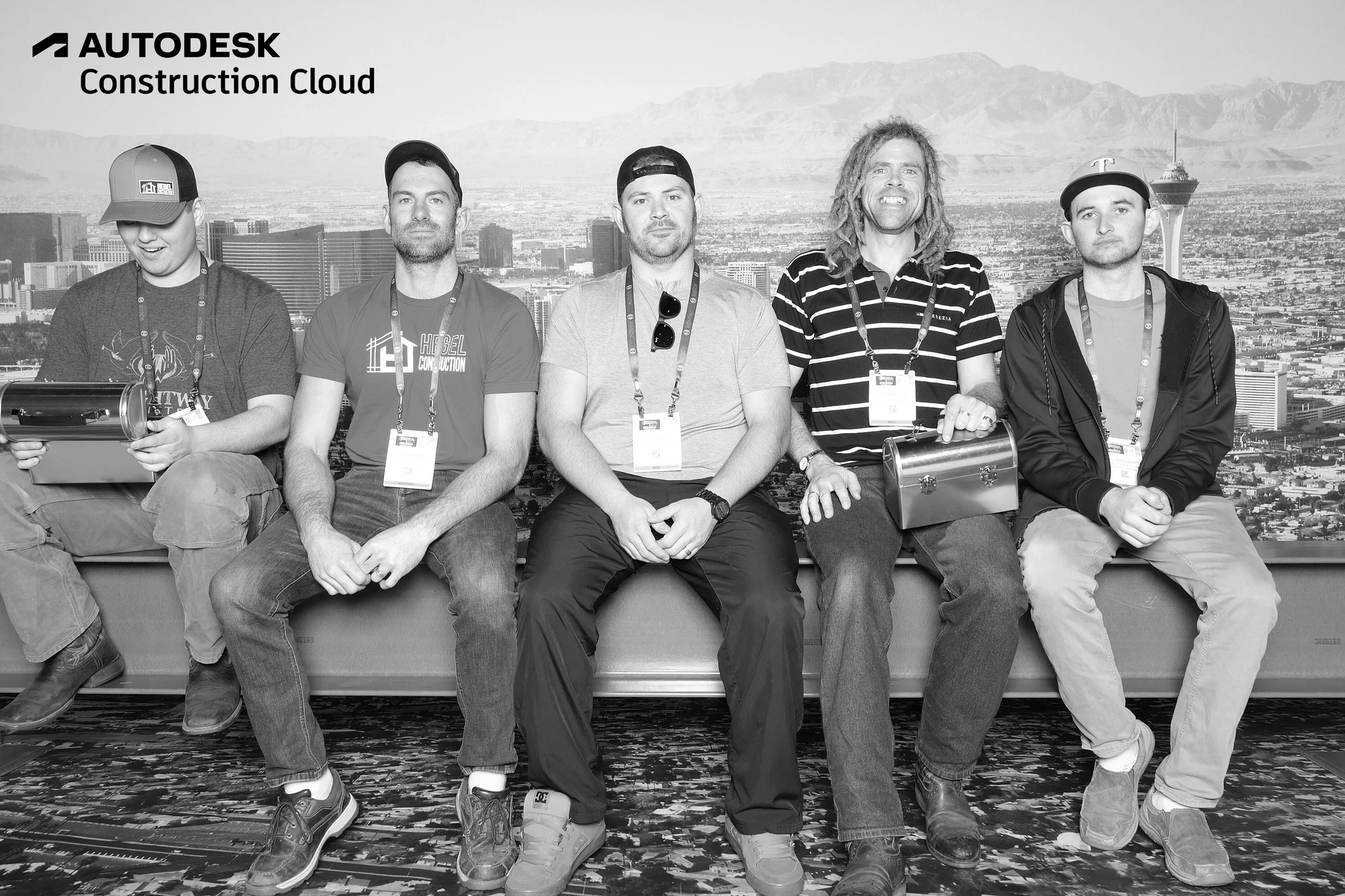 Five guests in caps sitting in a row on the beam at Autodesk at World of Concrete 2025