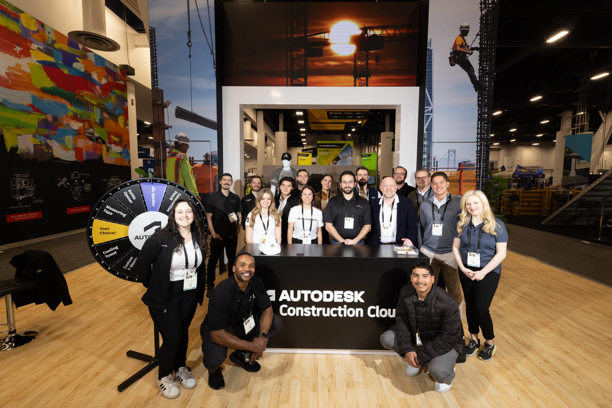 The booth team smiling in two rows in front of the desk at Autodesk at World of Concrete 2025