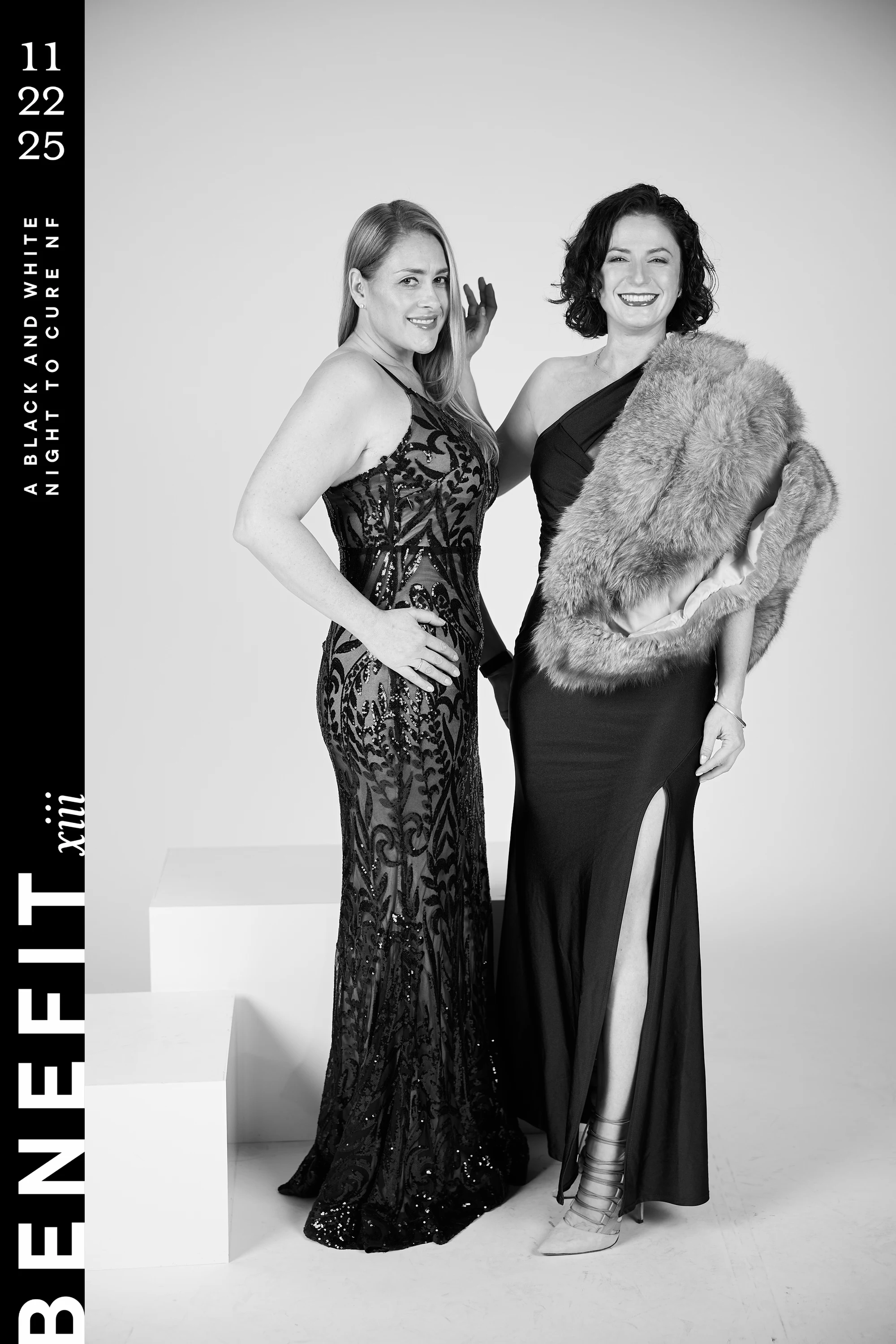 Black and white portrait of two women in long gowns, one with a fur stole over her shoulder at beNeFit XIII