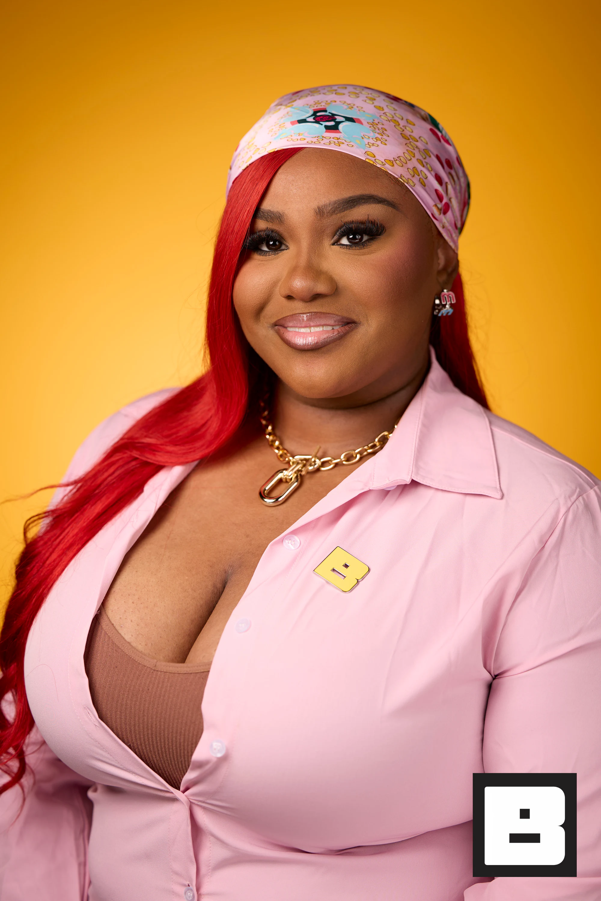 A headshot of a guest with red hair, a patterned headscarf and a pink jacket at Black Tech Week 2025