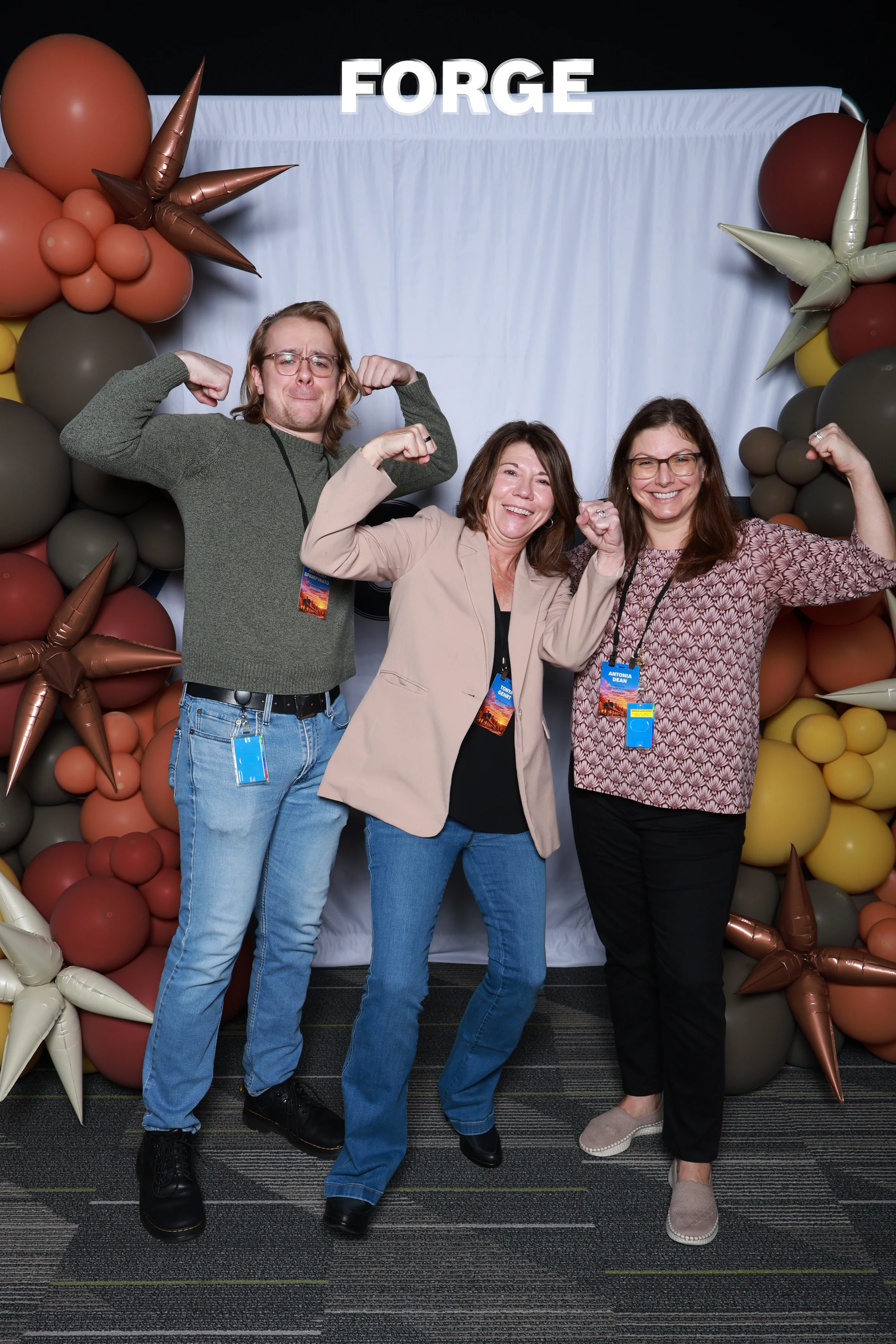 Three guests flexing in front of the FORGE drape at Bosch FORGE 2026