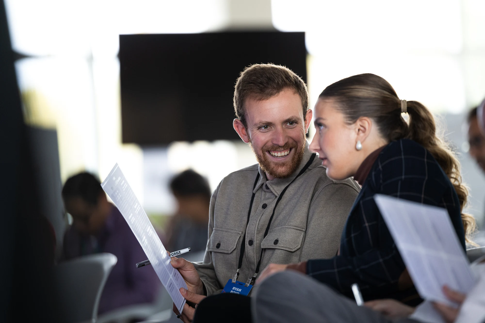Two attendees laughing over their notes in the audience at Bosch FORGE 2026