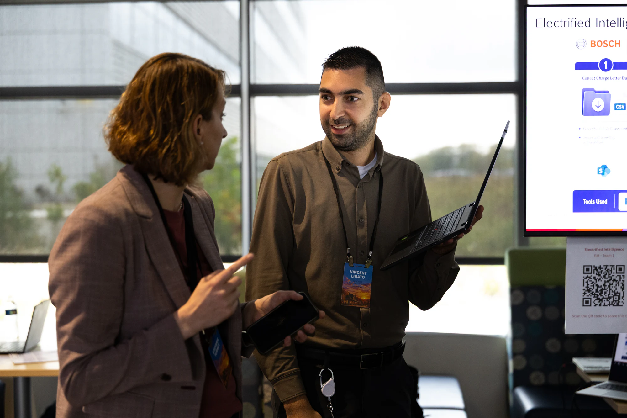 A man with a laptop walking a colleague through a demo in the marketplace at Bosch FORGE 2026