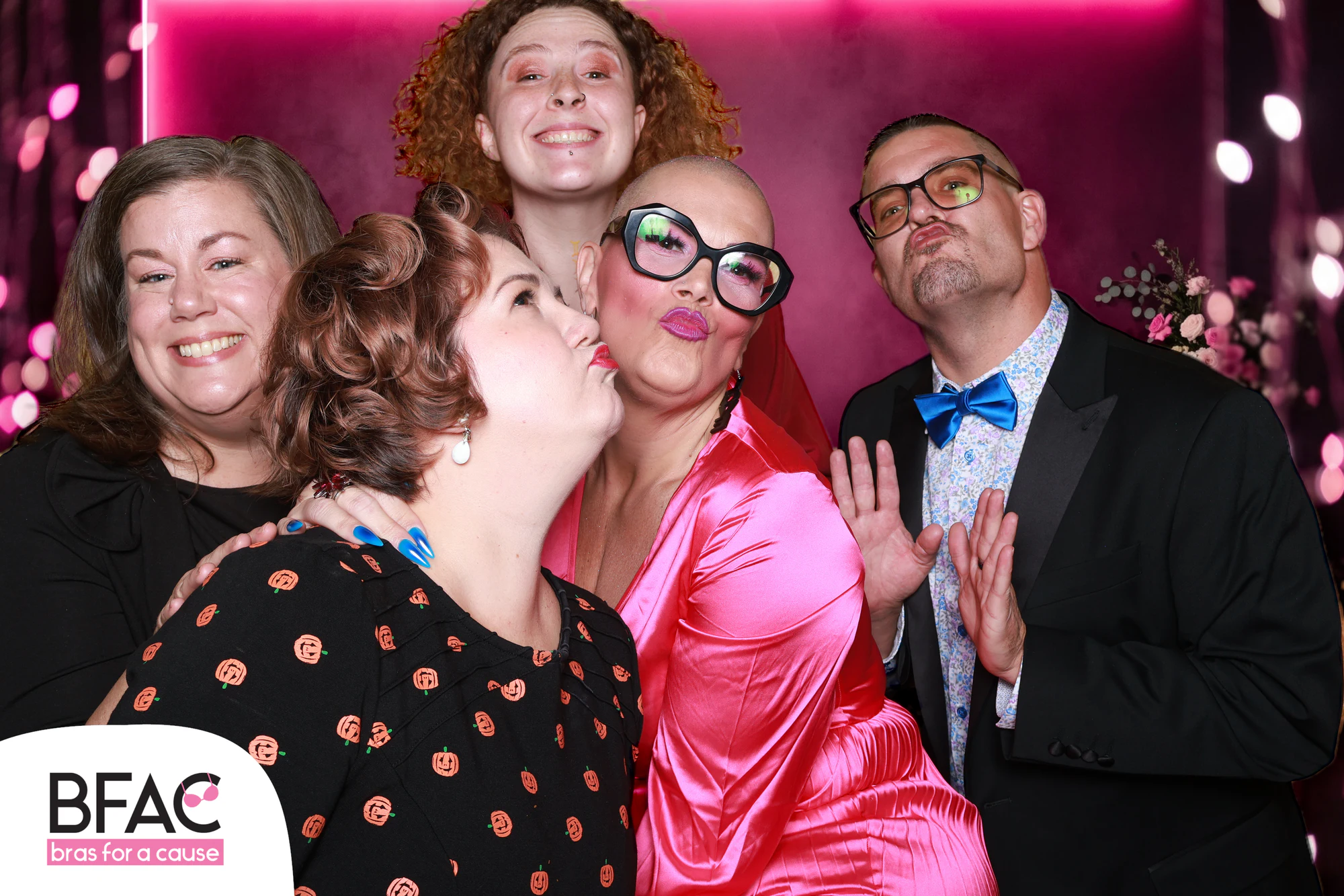 The six friends again, one woman kissing another on the cheek at Bras for a Cause 2026