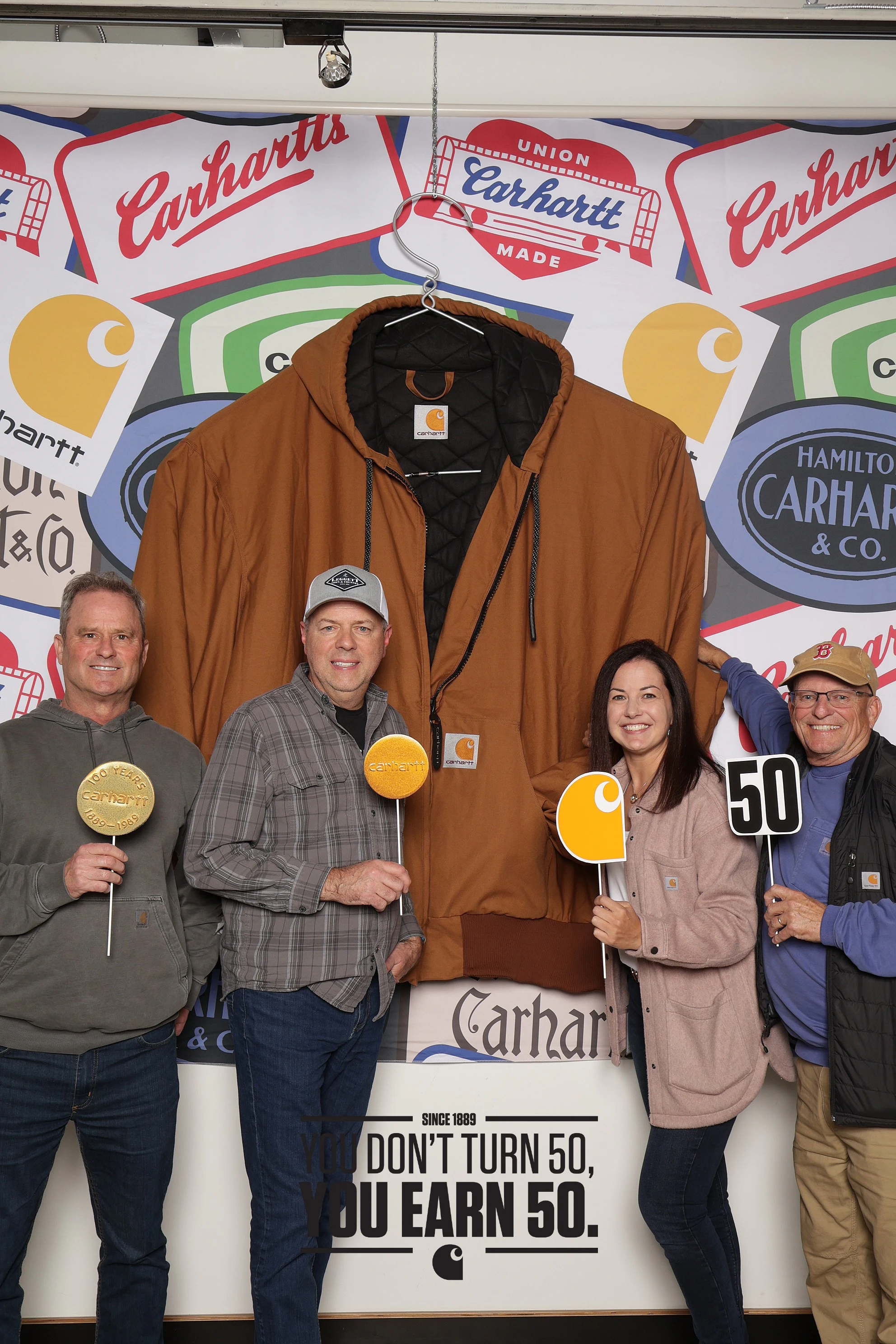 Five coworkers with props at the Carhartt Sales Meeting Welcome Party