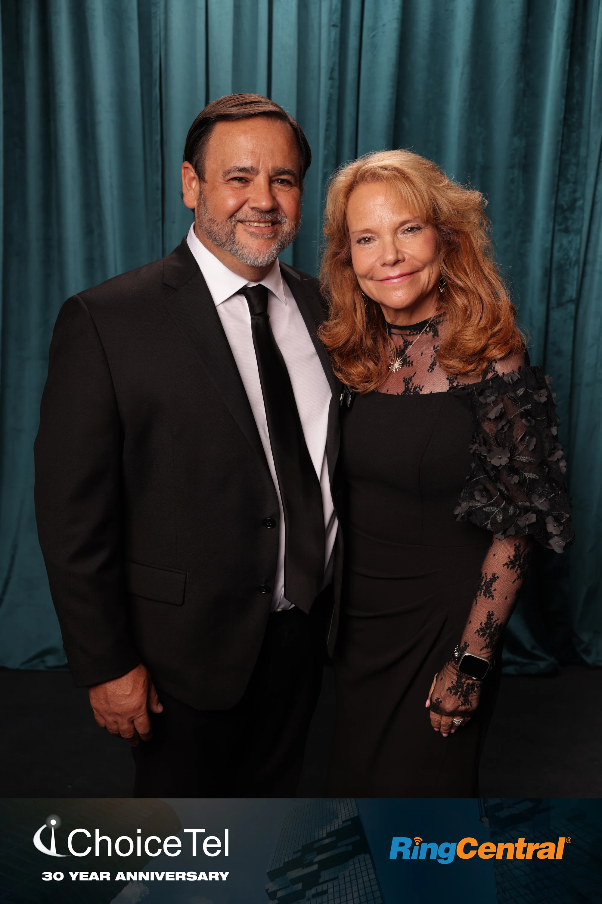 A couple in black in front of the teal drape at ChoiceTel 30 Year Anniversary at The Whitney