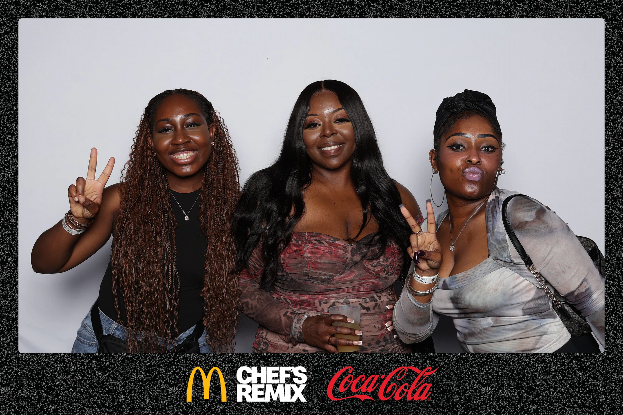 Three guests at the backdrop, two of them throwing peace signs at Coca-Cola x McDonald’s at the Jerk x Jollof Afterparty