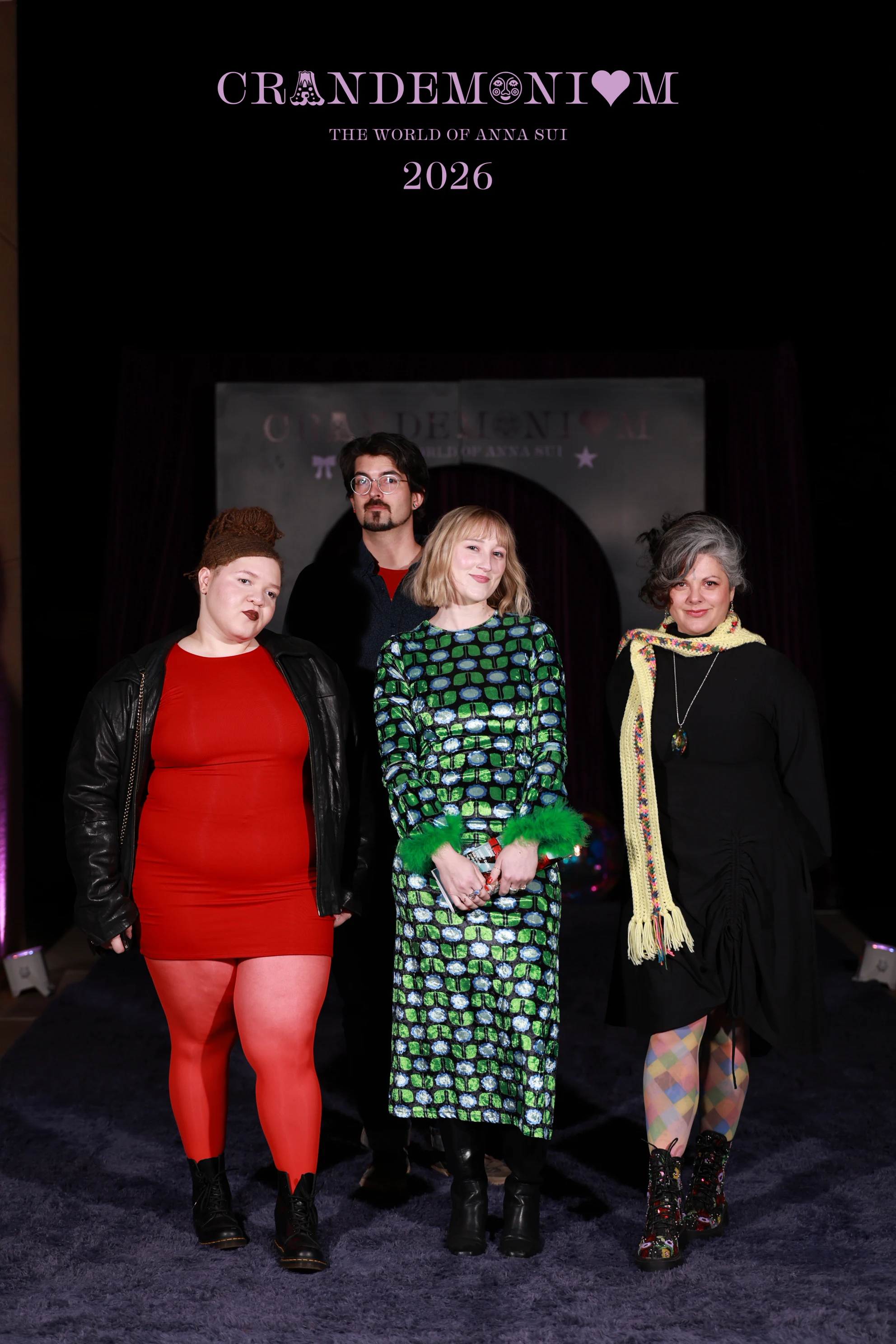 The four guests standing straight, the woman in black with a yellow scarf at Crandemonium 2026