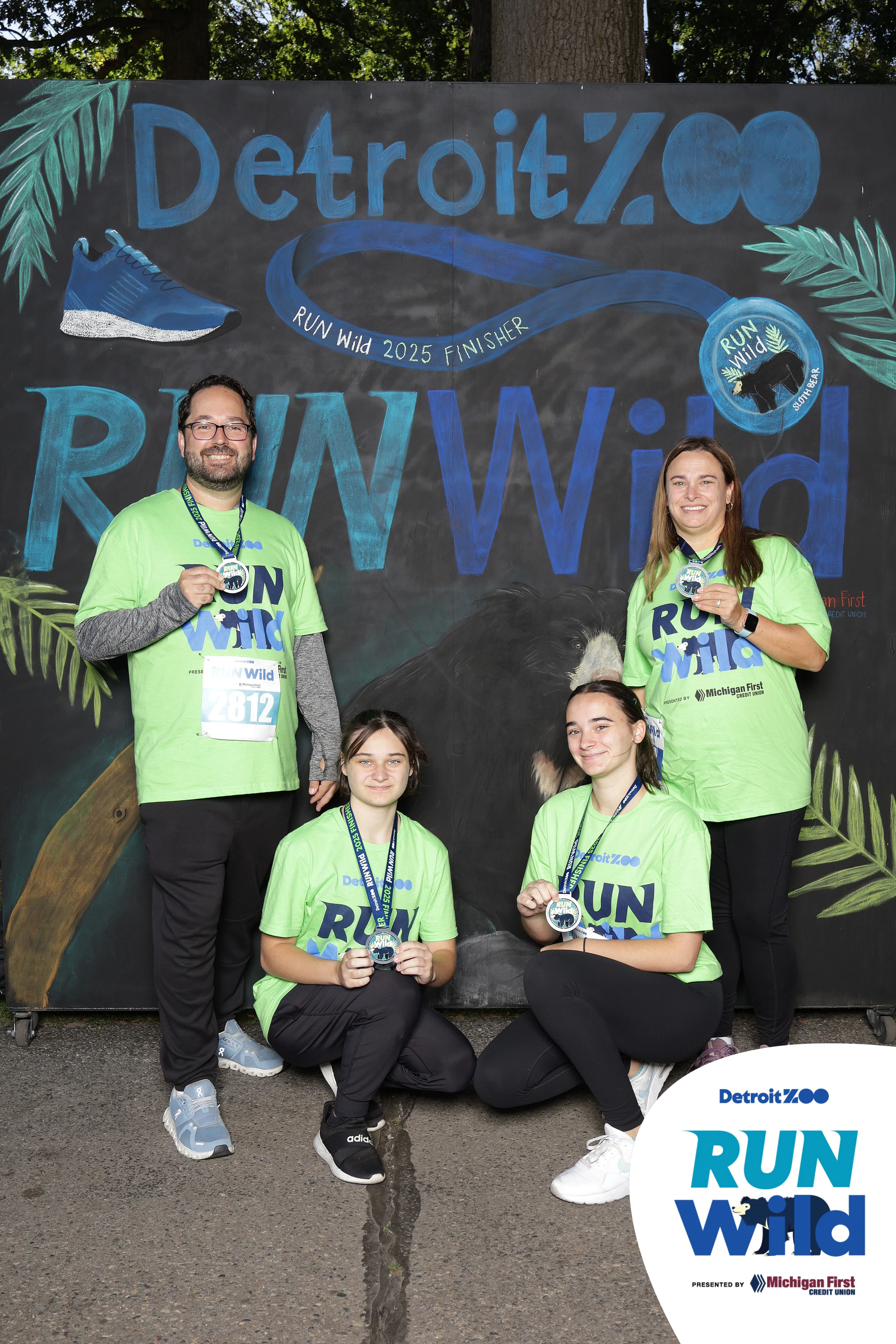 Family of five, medals on, kids in front at Detroit Zoo Event Series