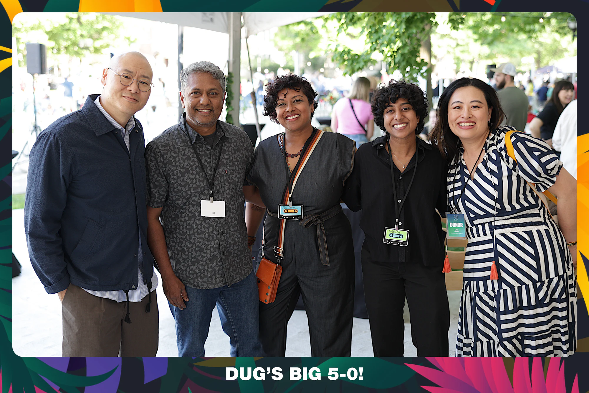 Five guests in lanyards with their arms around each other under the tent at Dug’s Big 5-0