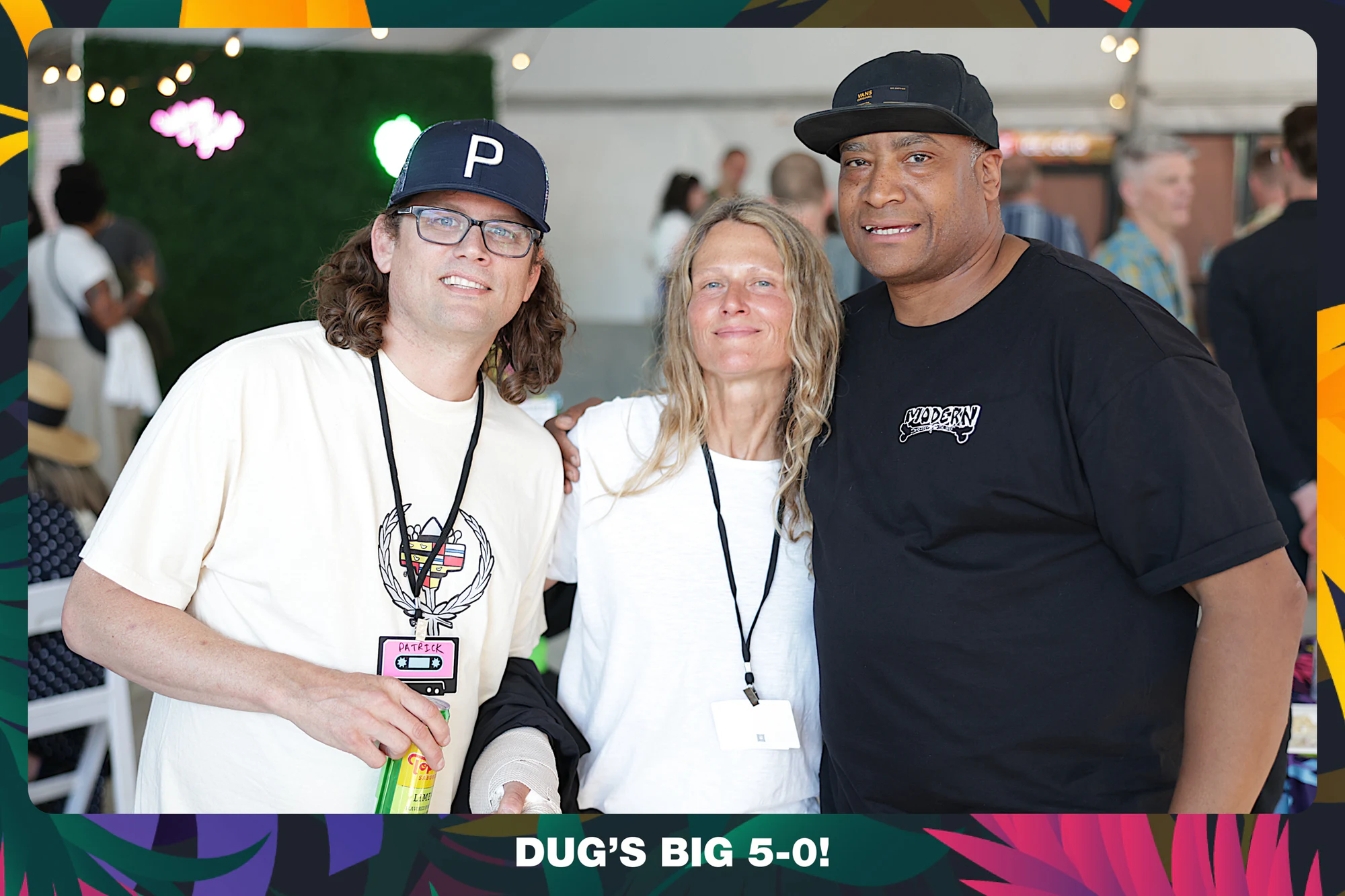 Three guests under the tent, one in a P cap holding a drink at Dug’s Big 5-0