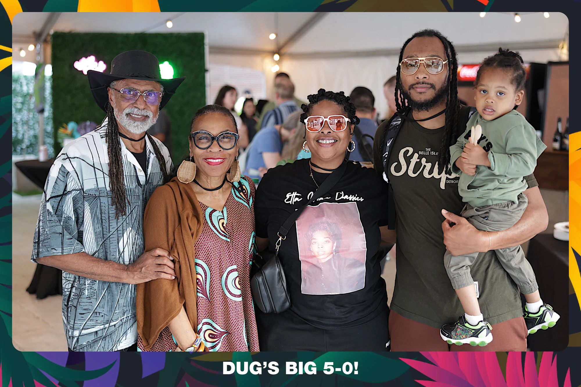 Four guests and a toddler under the tent, one in a wide-brimmed hat at Dug’s Big 5-0