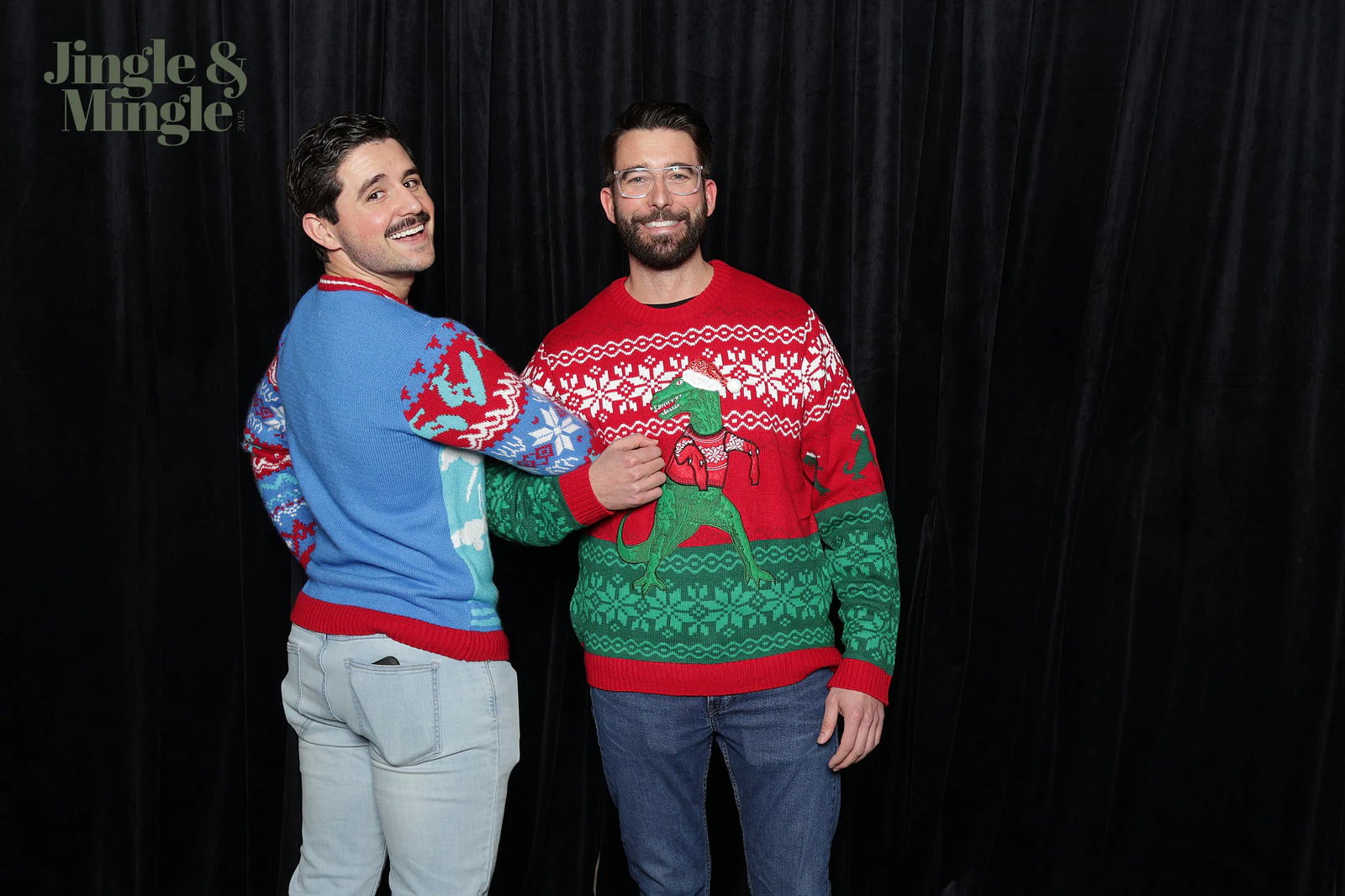 Two men in Christmas sweaters, one looking back over his shoulder, in front of the black velvet at Dwyer Marble and Stone