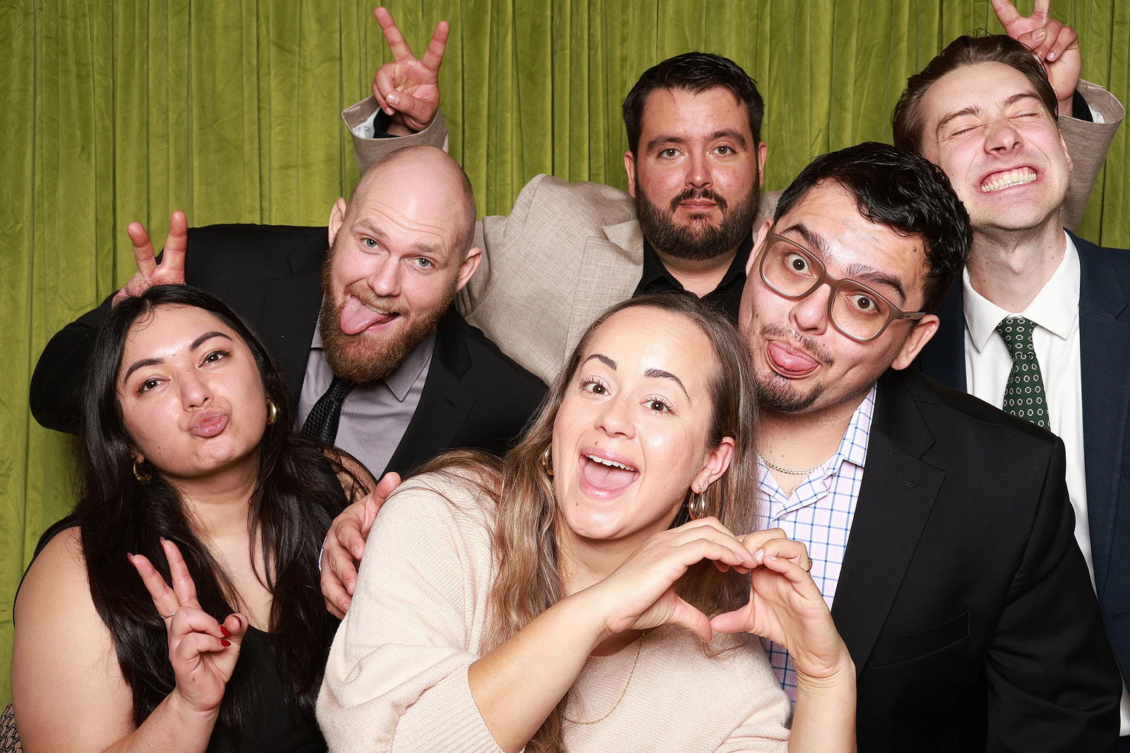 Six guests clowning, heart hands in front and bunny ears behind, two with their tongues out at the DYC Tasting