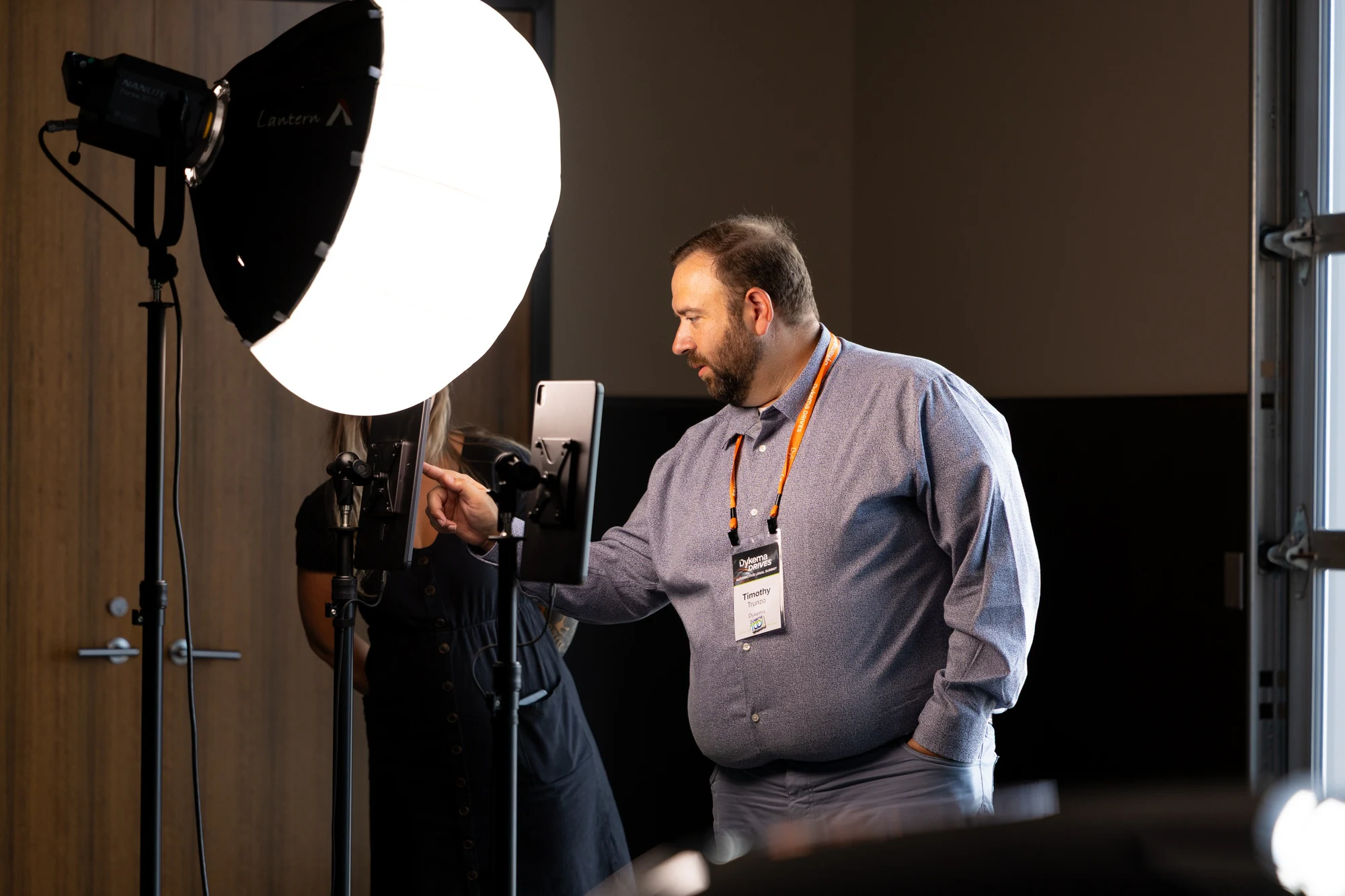 An attendee tapping the booth screen next to a large lantern light at Dykema Automotive Legal Summit 2026
