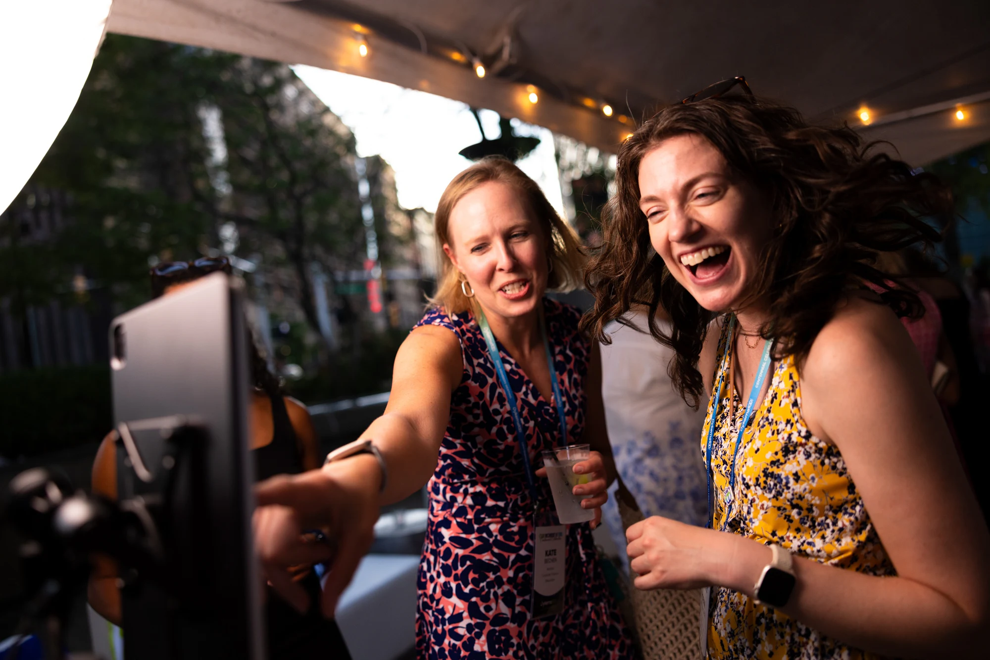 Two guests mid-laugh at the booth at Dykema Centennial Celebration