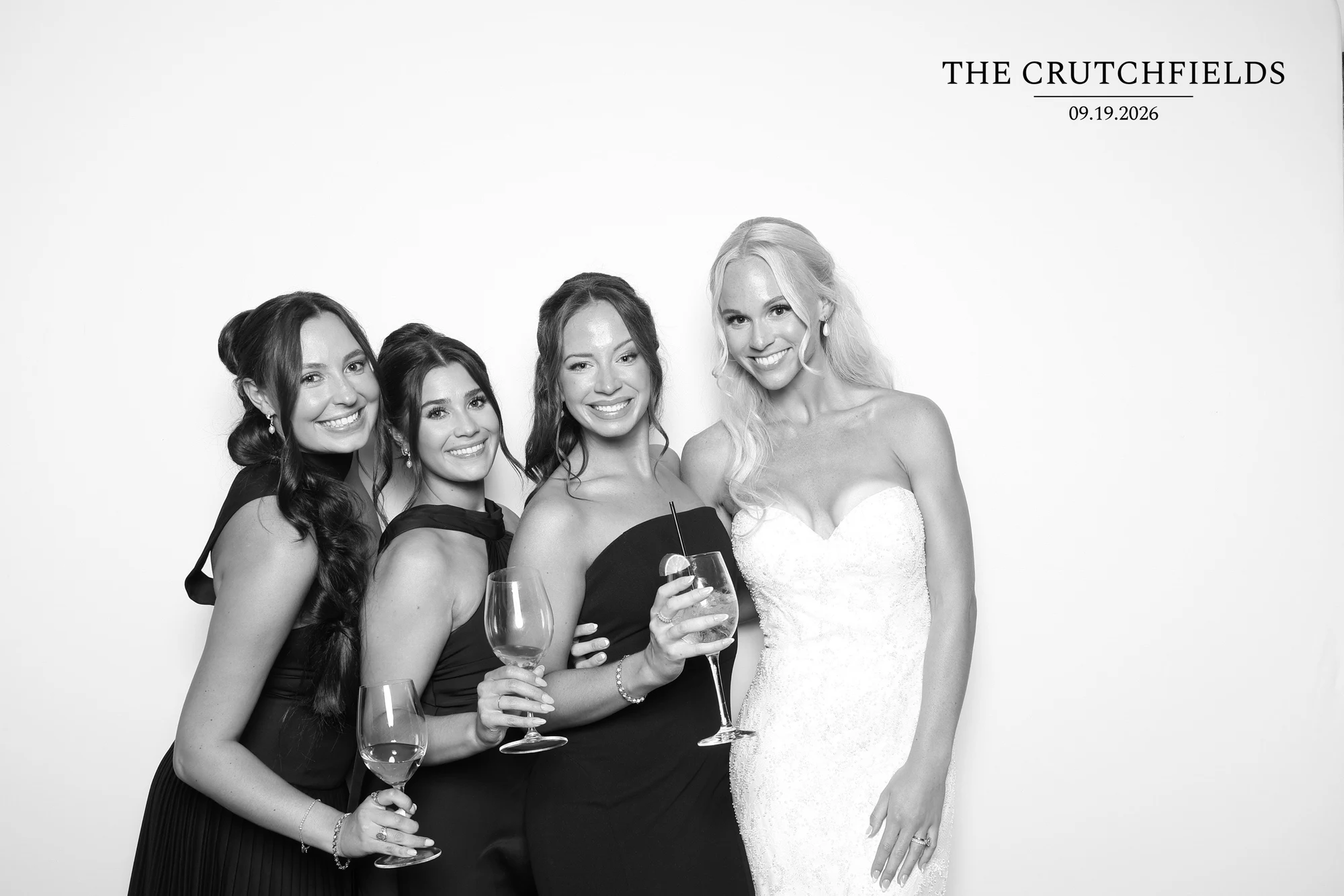 Four women with wine glasses, one in a strapless white gown at Elizabeth + Kyle