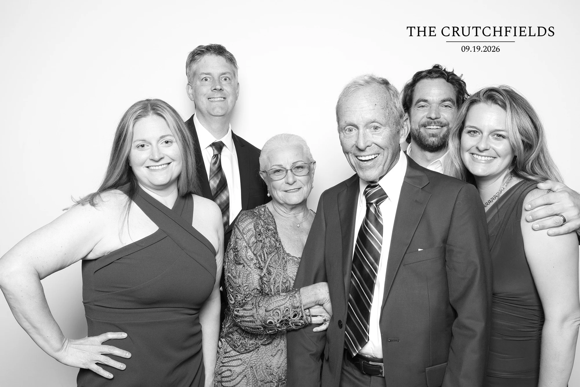 Six guests standing close, three women and three men in suits at Elizabeth + Kyle