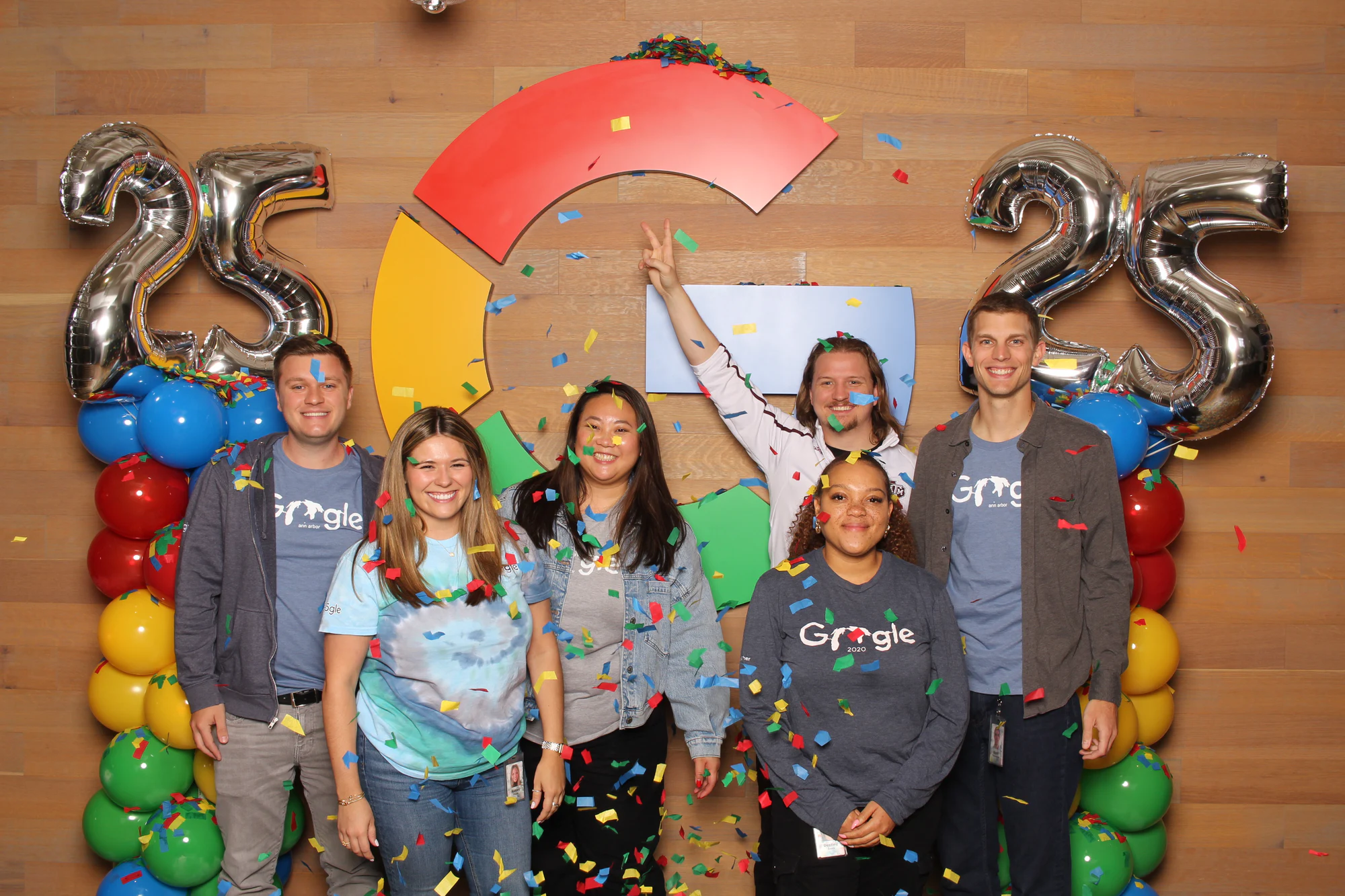 The nine smiling at the camera between the balloon columns at Google’s 25th Birthday