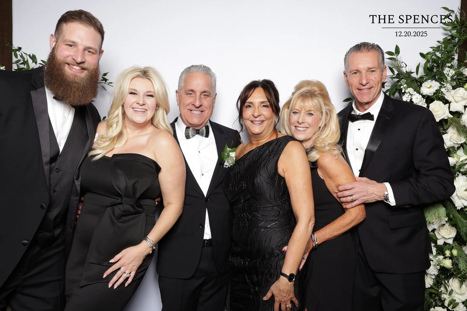 Six guests in black tie standing in a row at Jessica + Rory