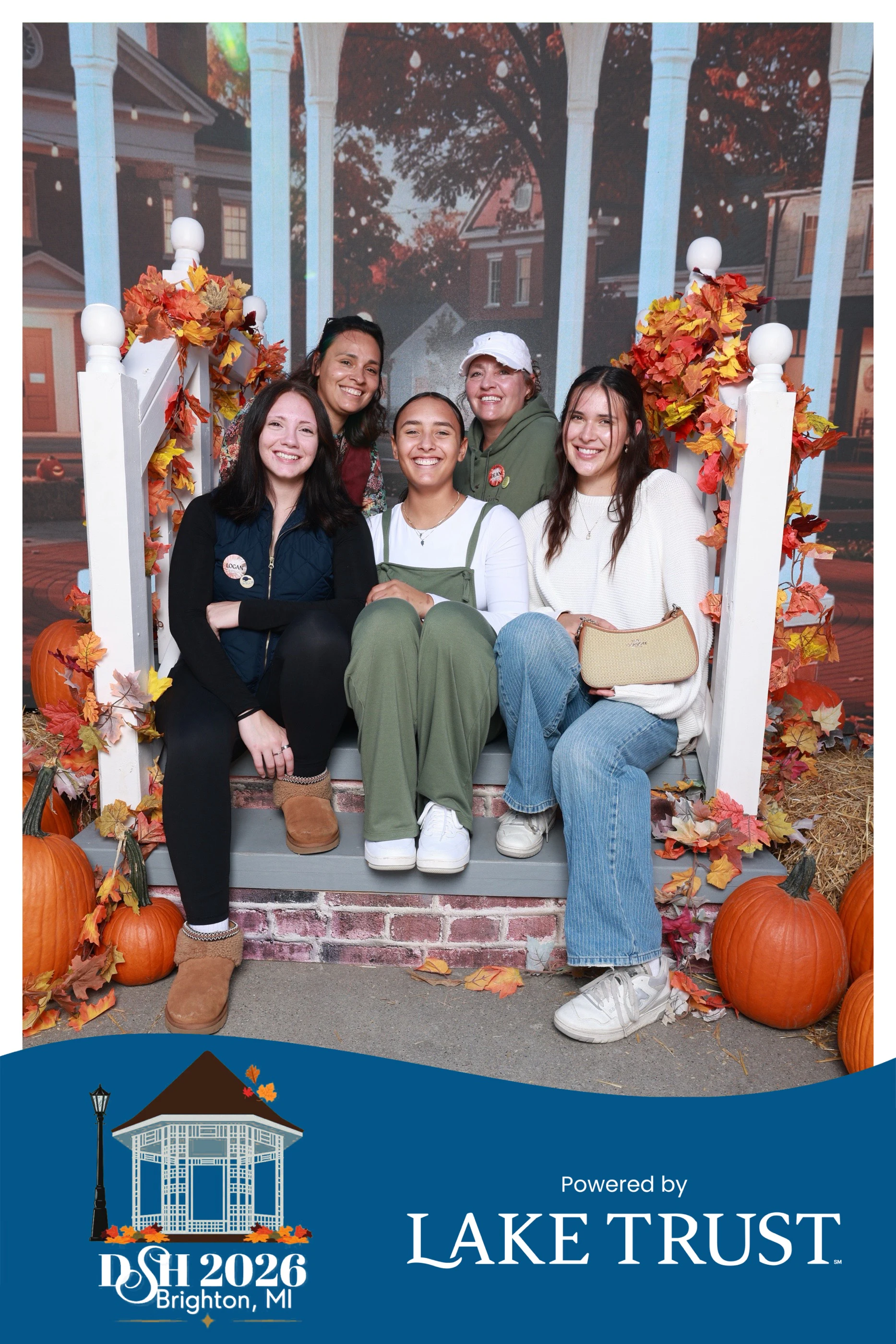 Five guests sitting close on the porch steps between the pumpkins at Destination Starz Hollow
