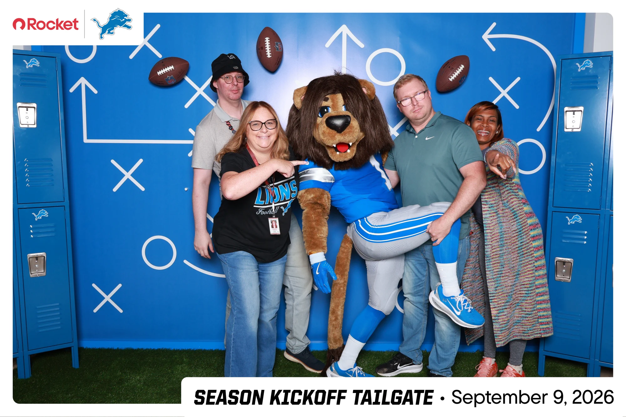 Four guests with the mascot stretched sideways across their arms at Lions Season Launch Week